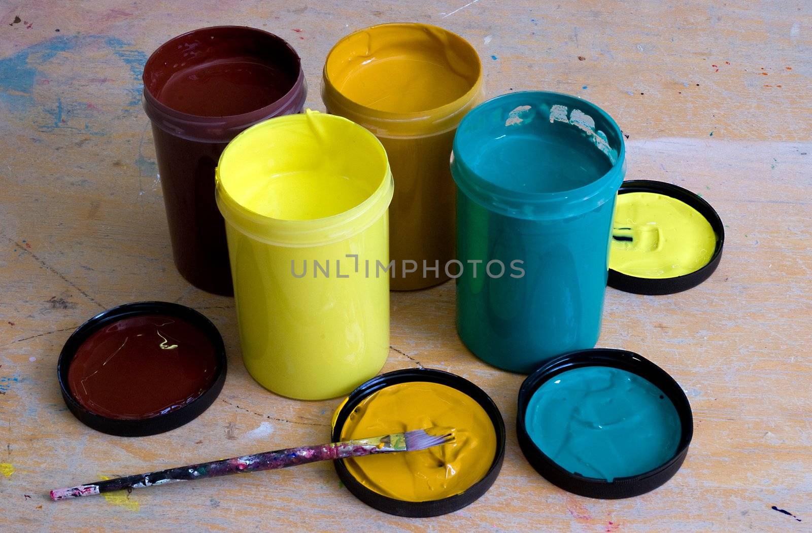 A group of 4 acrylic paint tubs on a work bench