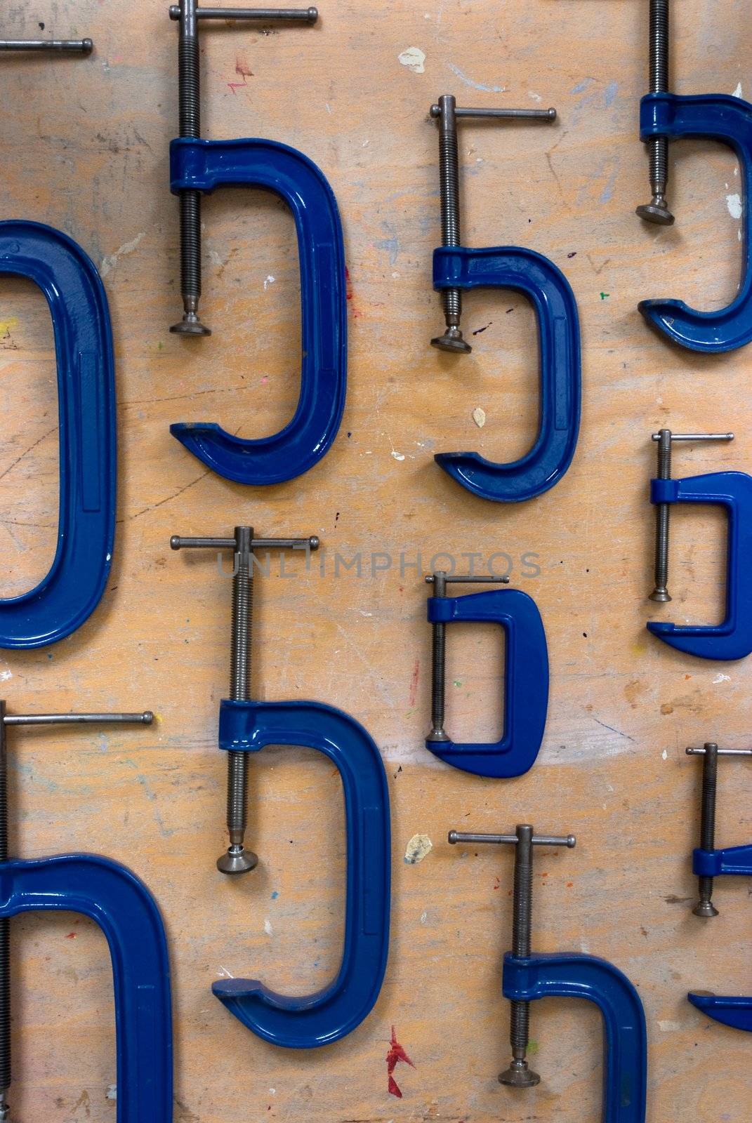 Different sizes of G Clamps on a wooden background