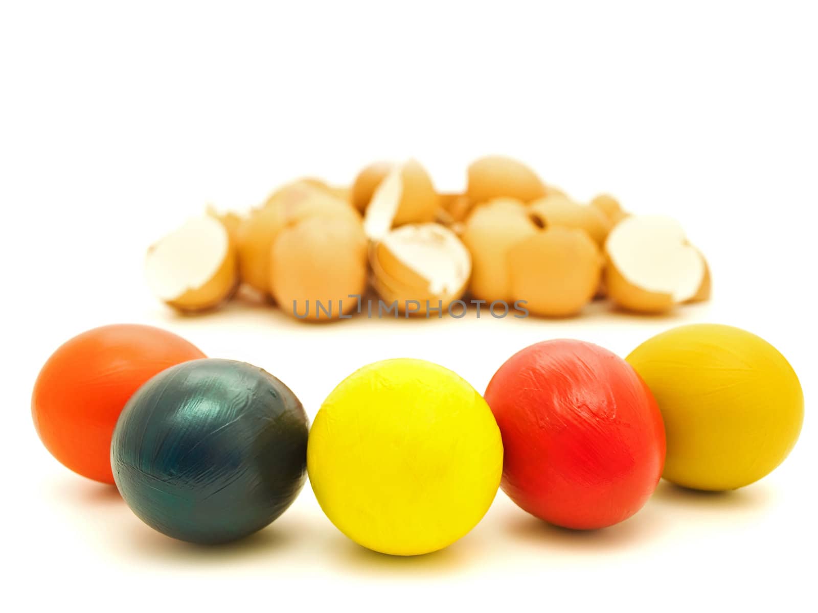 Multicolored easter eggs agains heap of egg shell