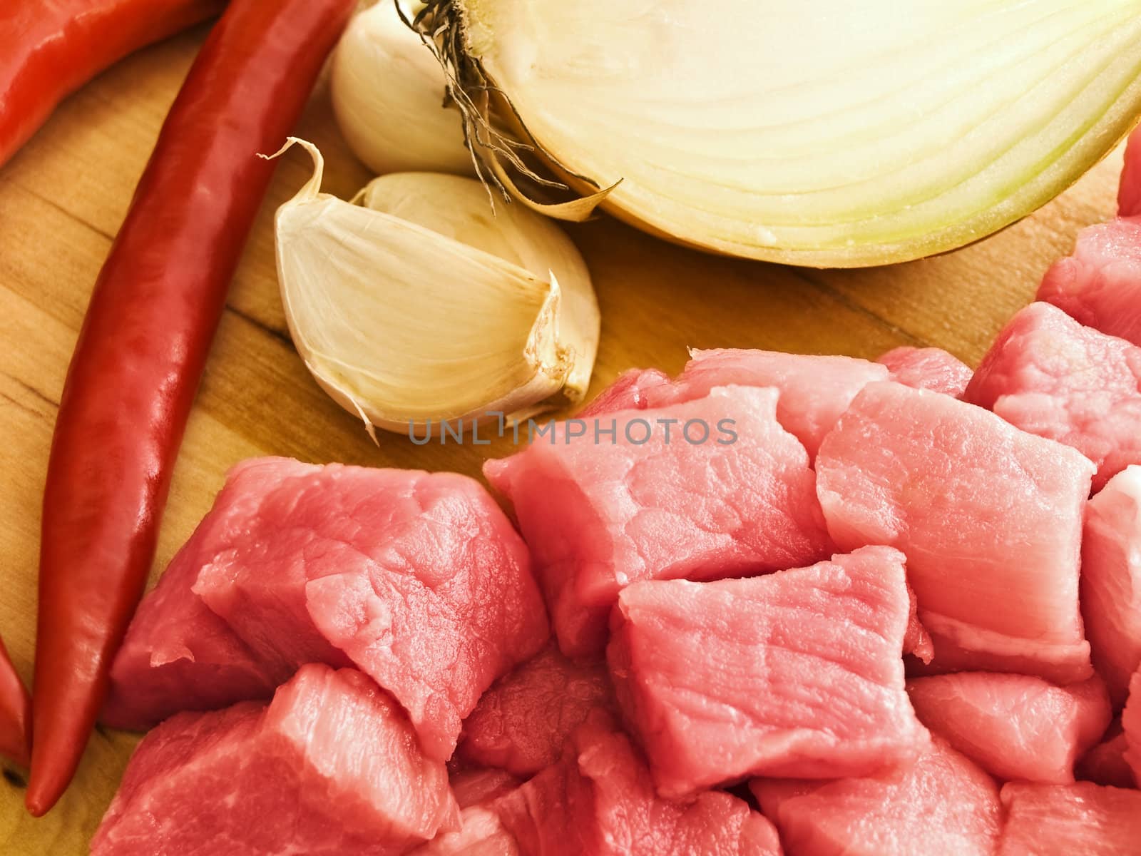 pieces of meat with pepper,garlic and onion on hardboard