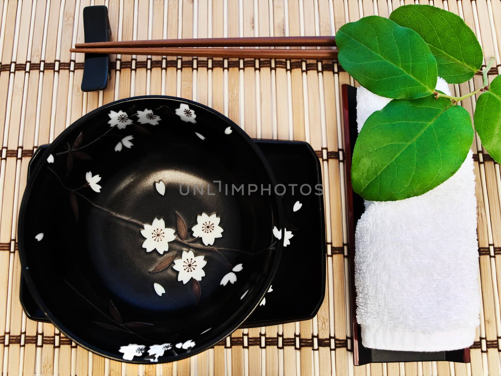 oriental style table serving with bowl and green leaves 