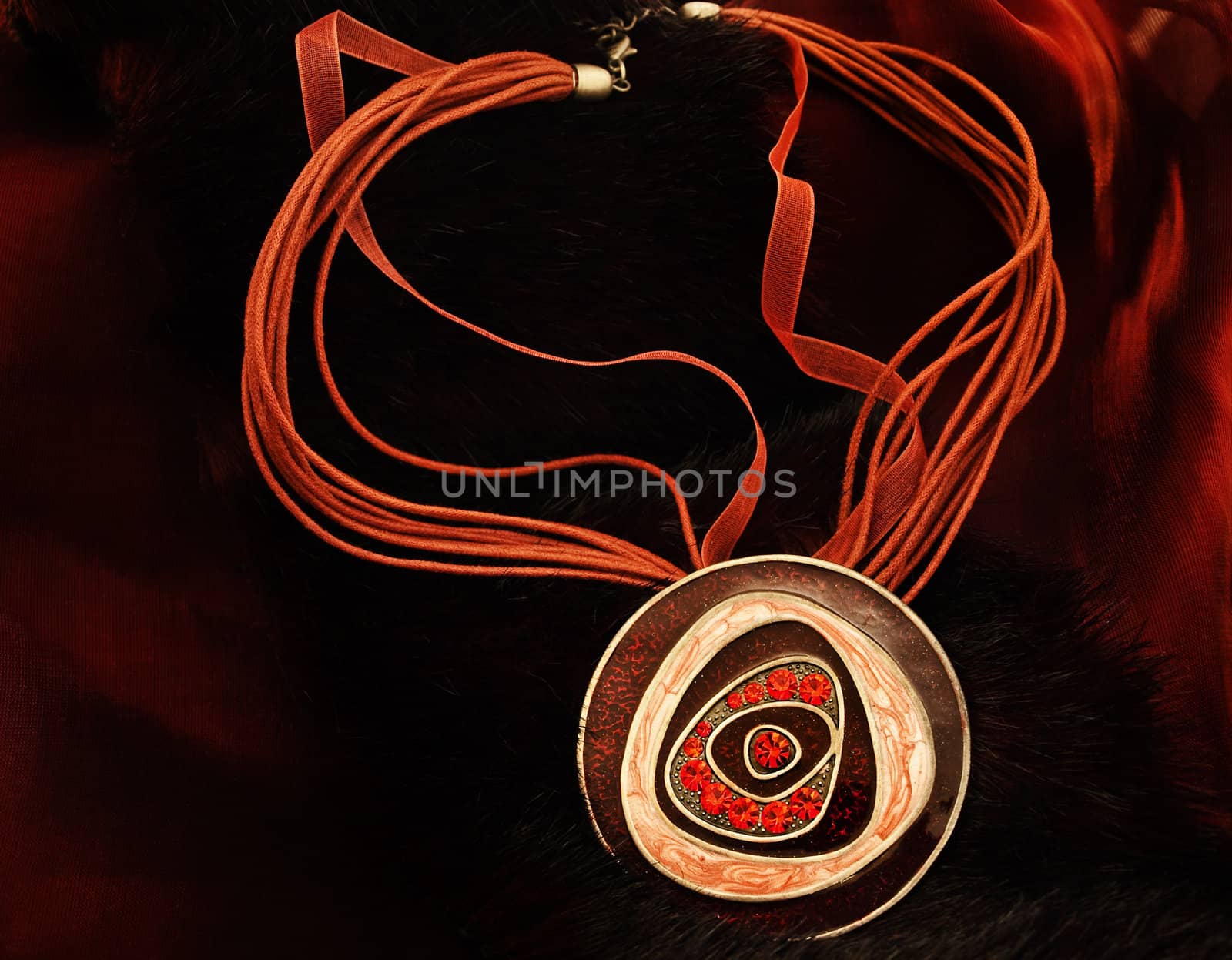 fashion necklace with bright red gems over burgundy color background