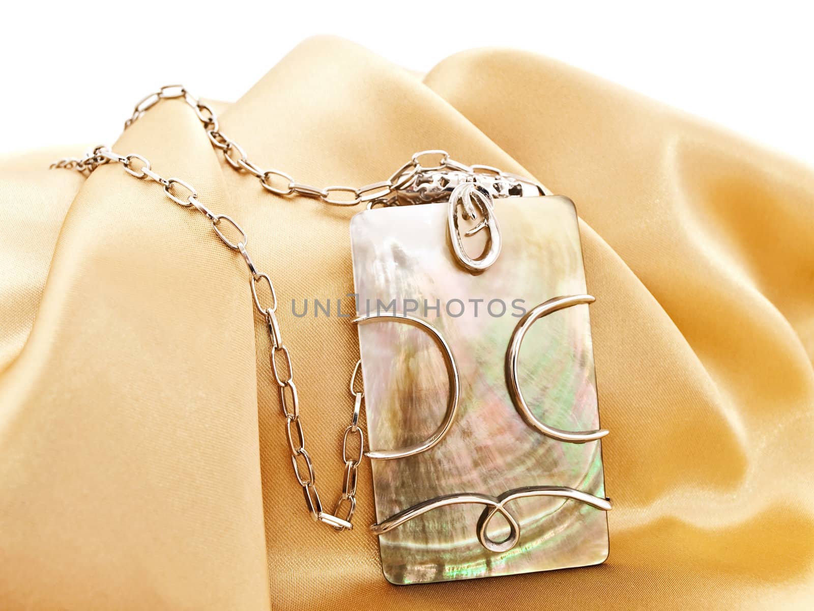  fashion necklace with metal decoration over golden textile background