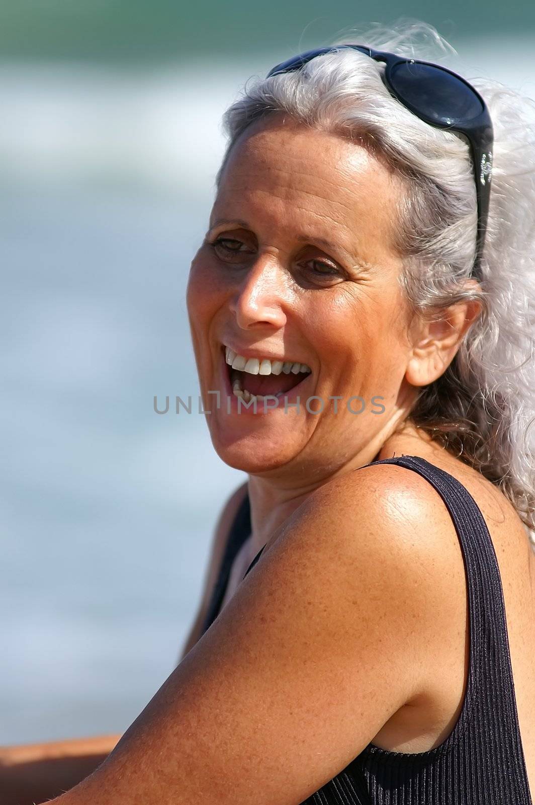 an older female laughing at the beach