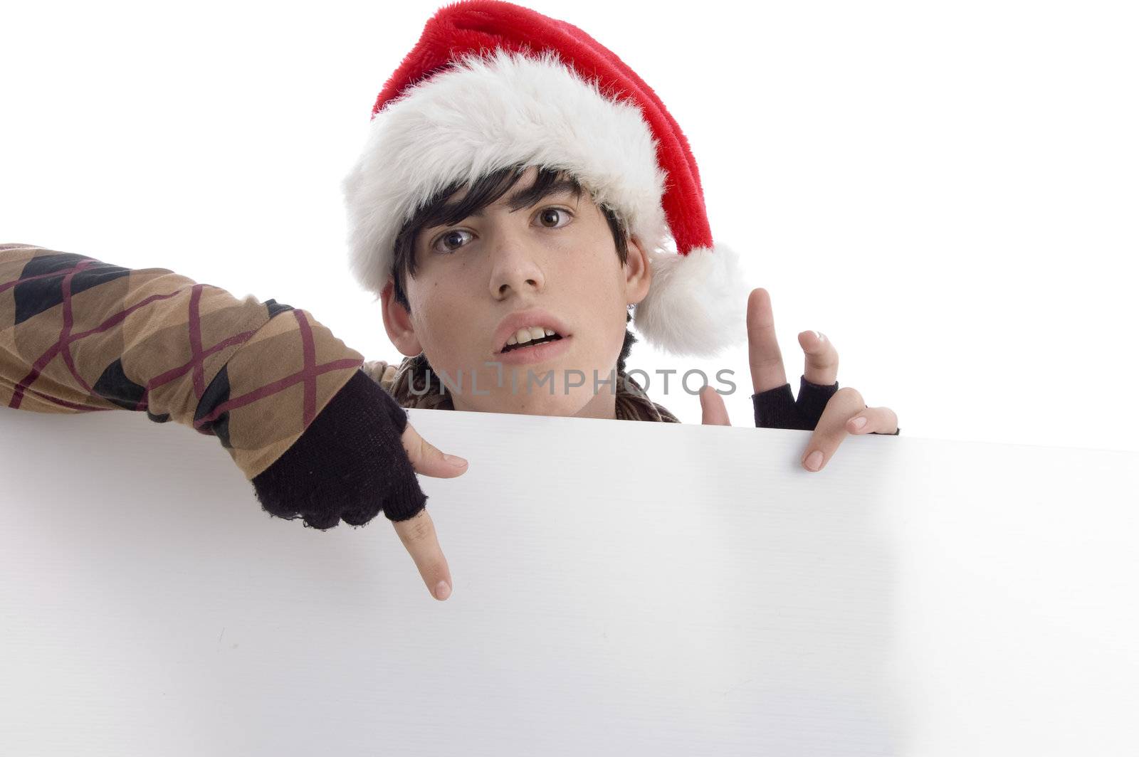 young boy wearing christmas hat indicating placard with white background