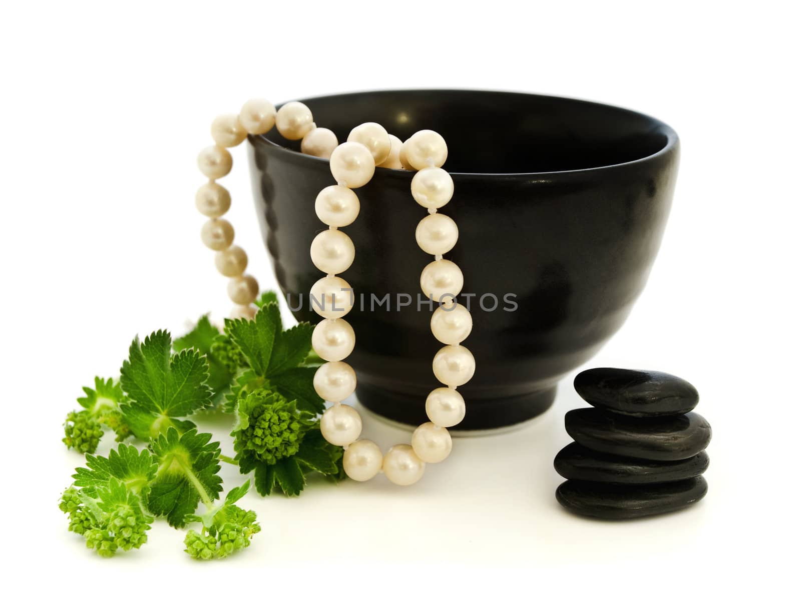 Relax theme with pearl beads, Zen stones and green herb over white background