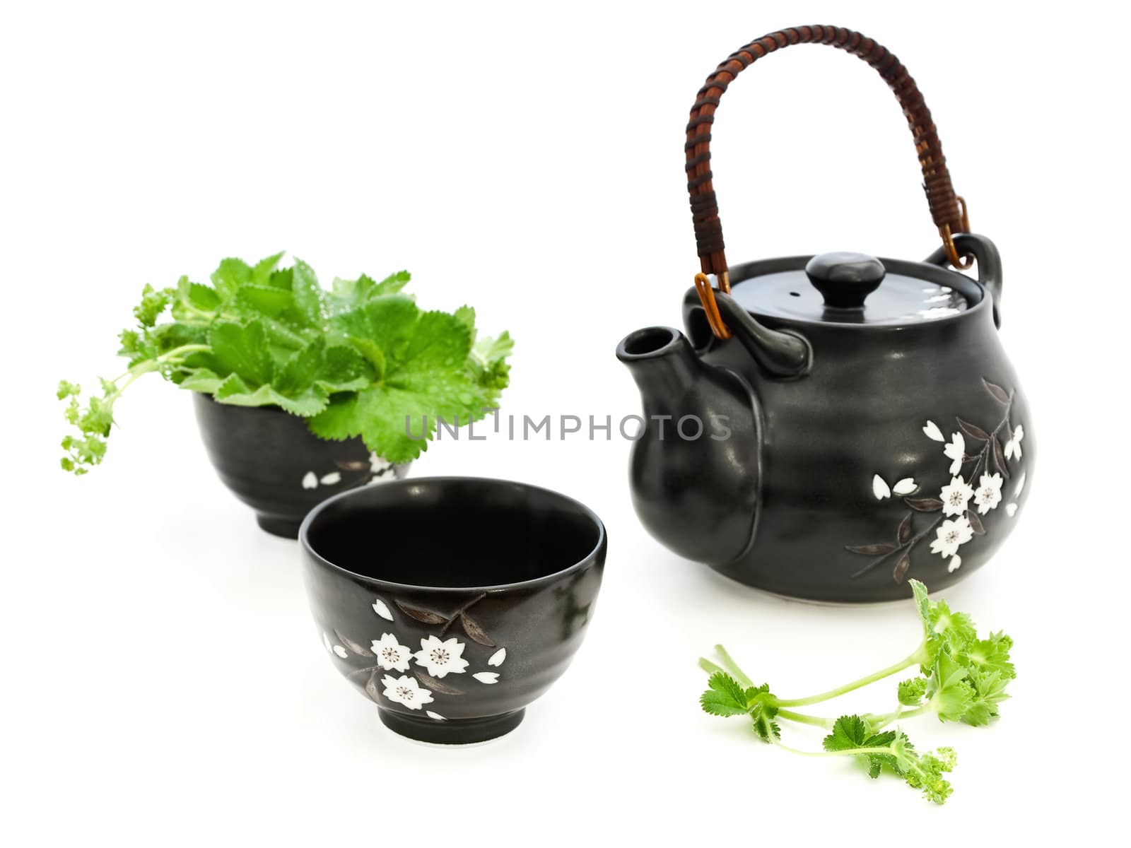 tea set with greens over the white background