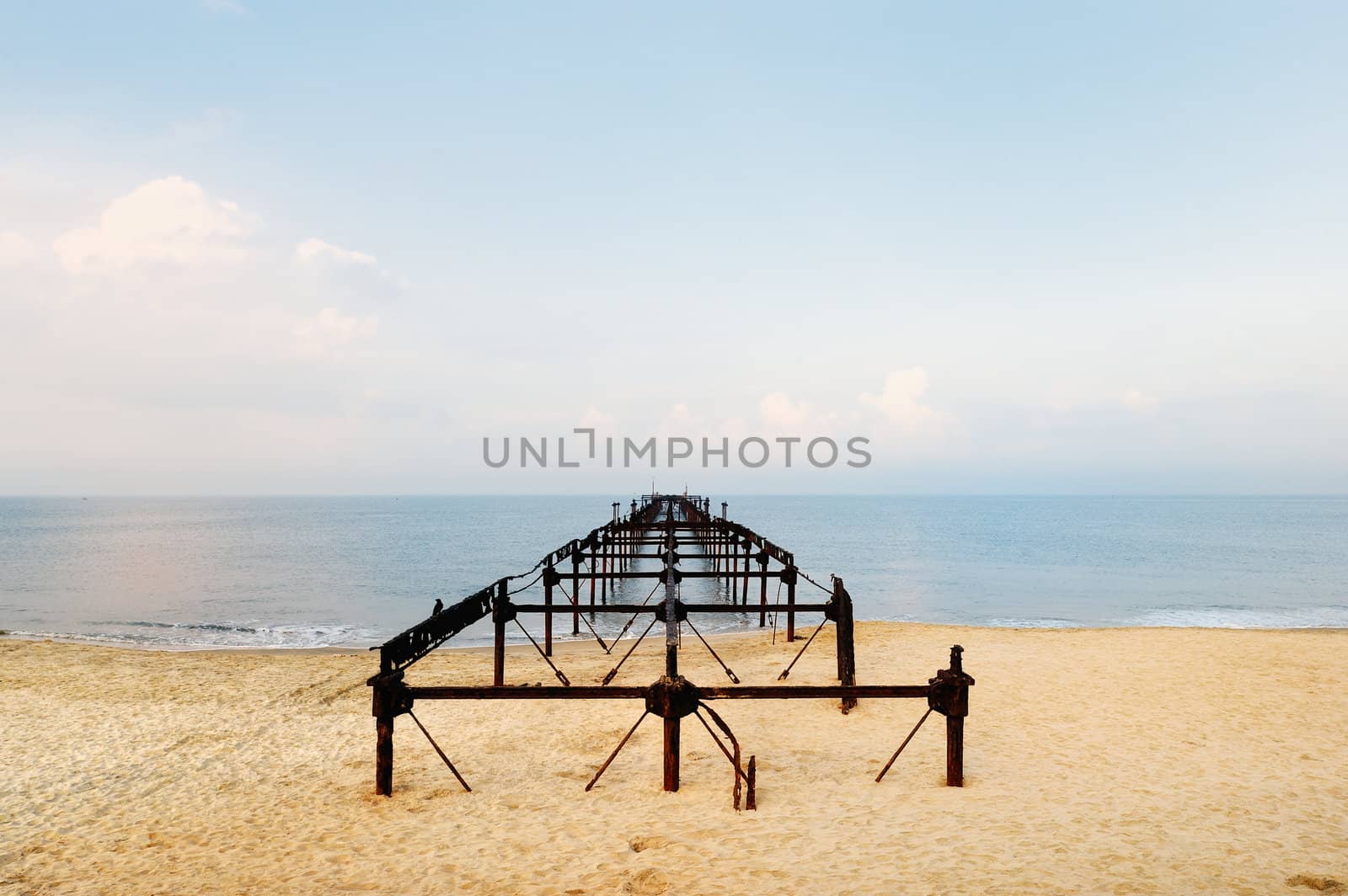Old iron bridge in perspective on the sea coast