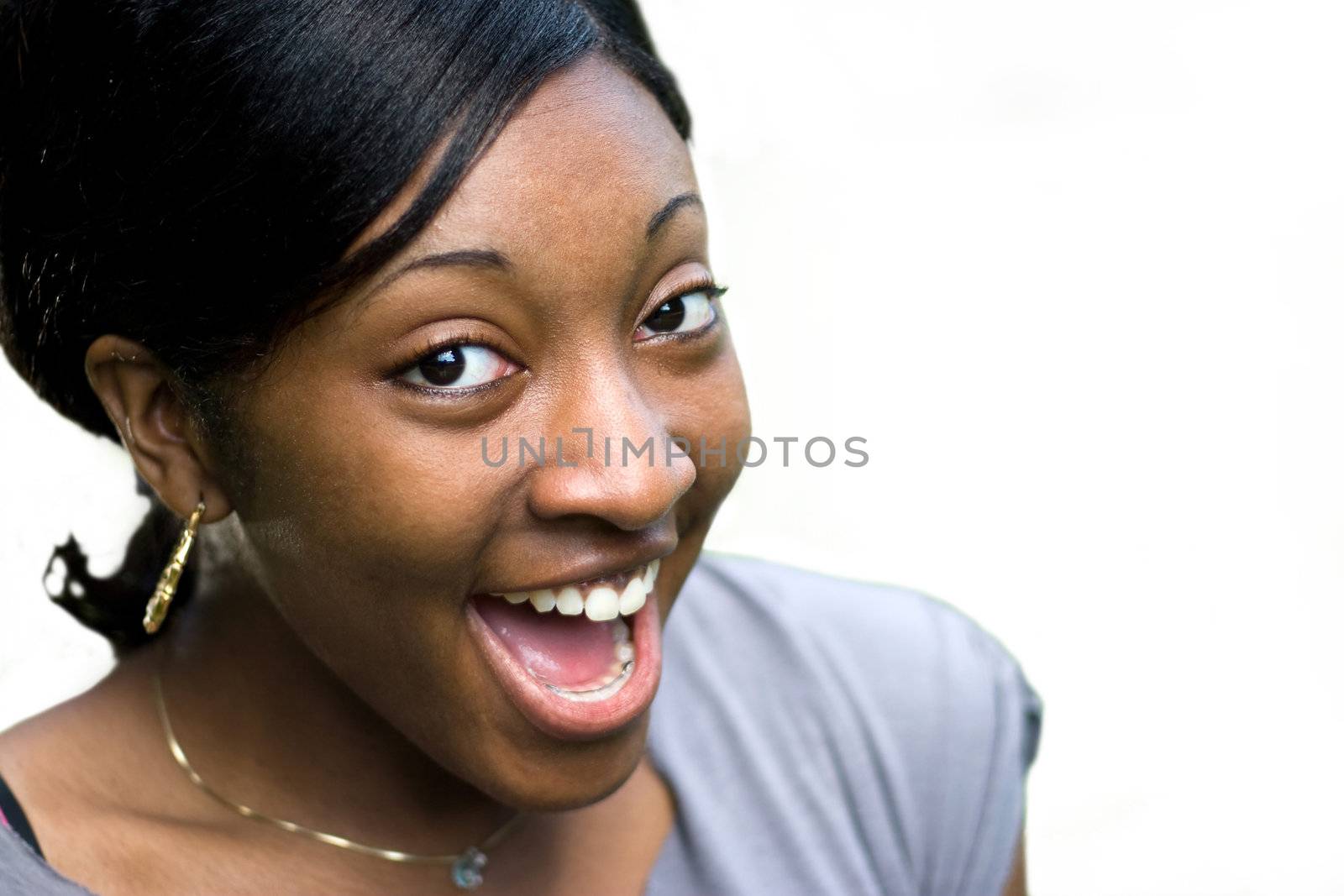 A happy or surprised young black woman isolated over a white background.  Clipping path is included for easy isolation.