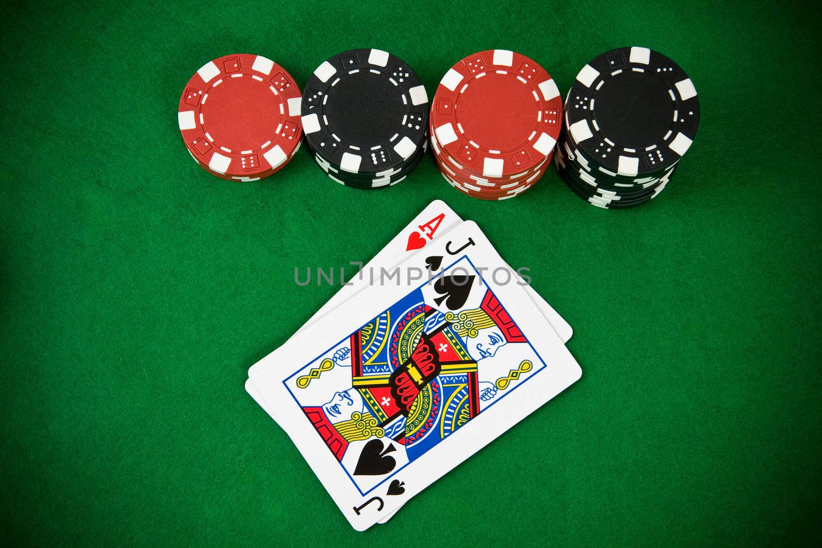 Ace of hearts and black jack with black and red poker chips. Top view.
