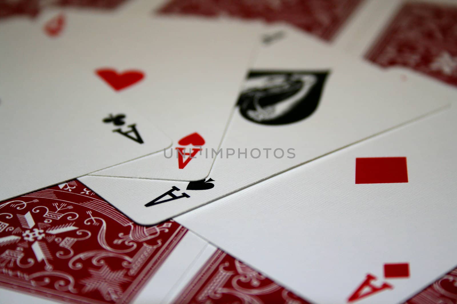 Close up of four aces on a pile of cards.
