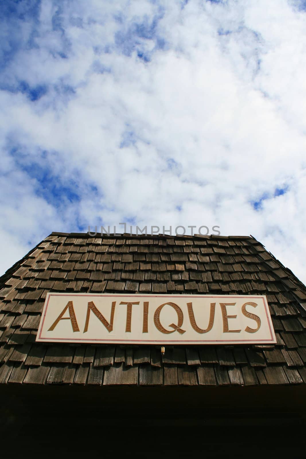 Close up of an antiques sign on top of a store.
