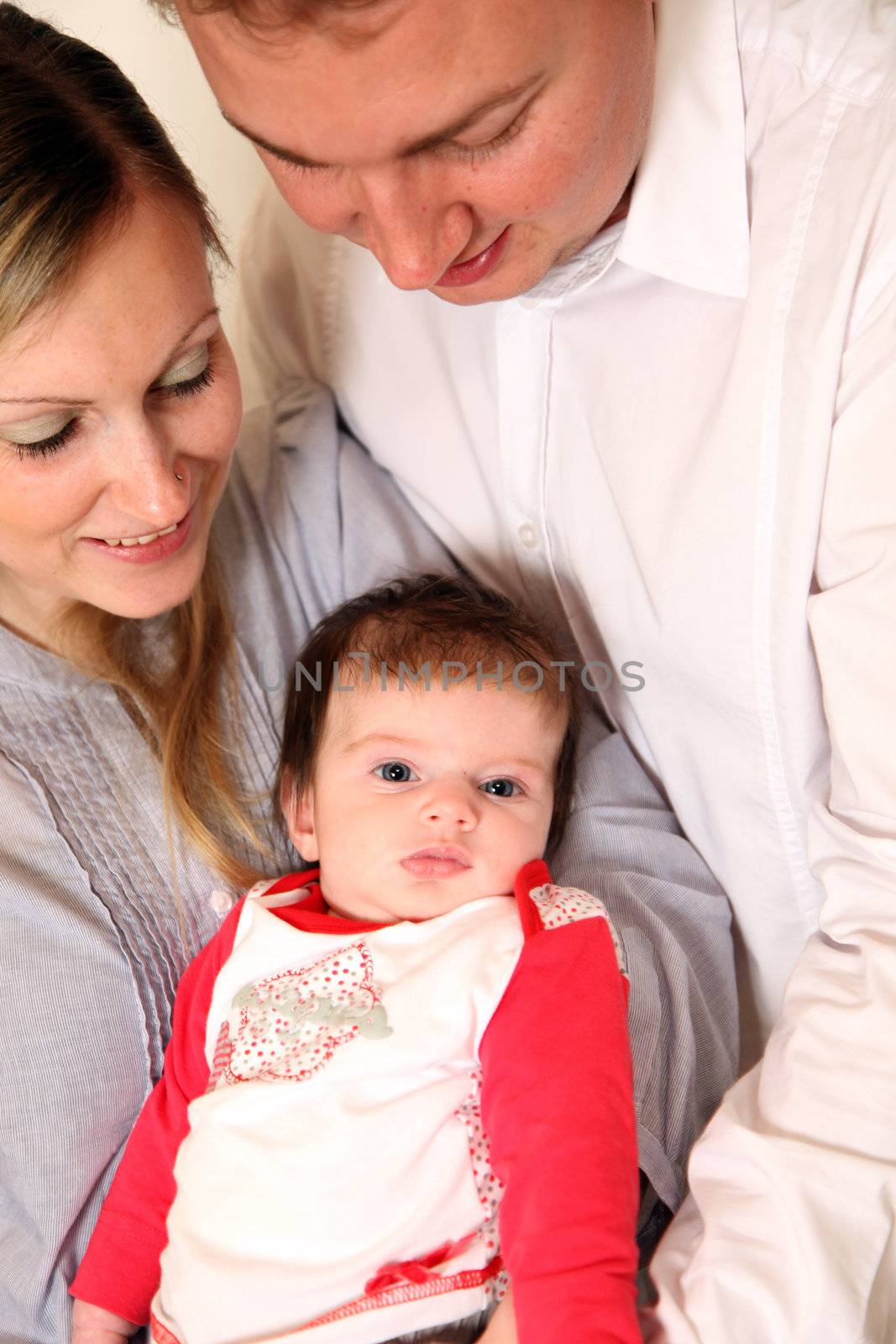 Young family with a baby. Parents keep their child lovingly in his arms