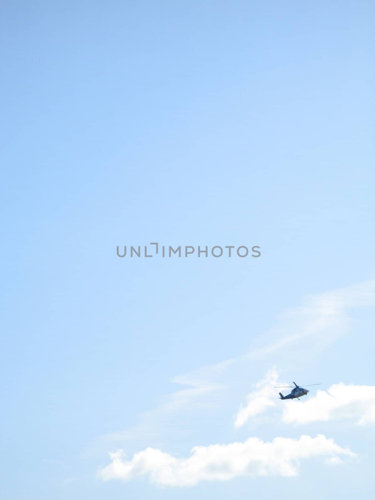 a helicopter in the blue cloudy sky