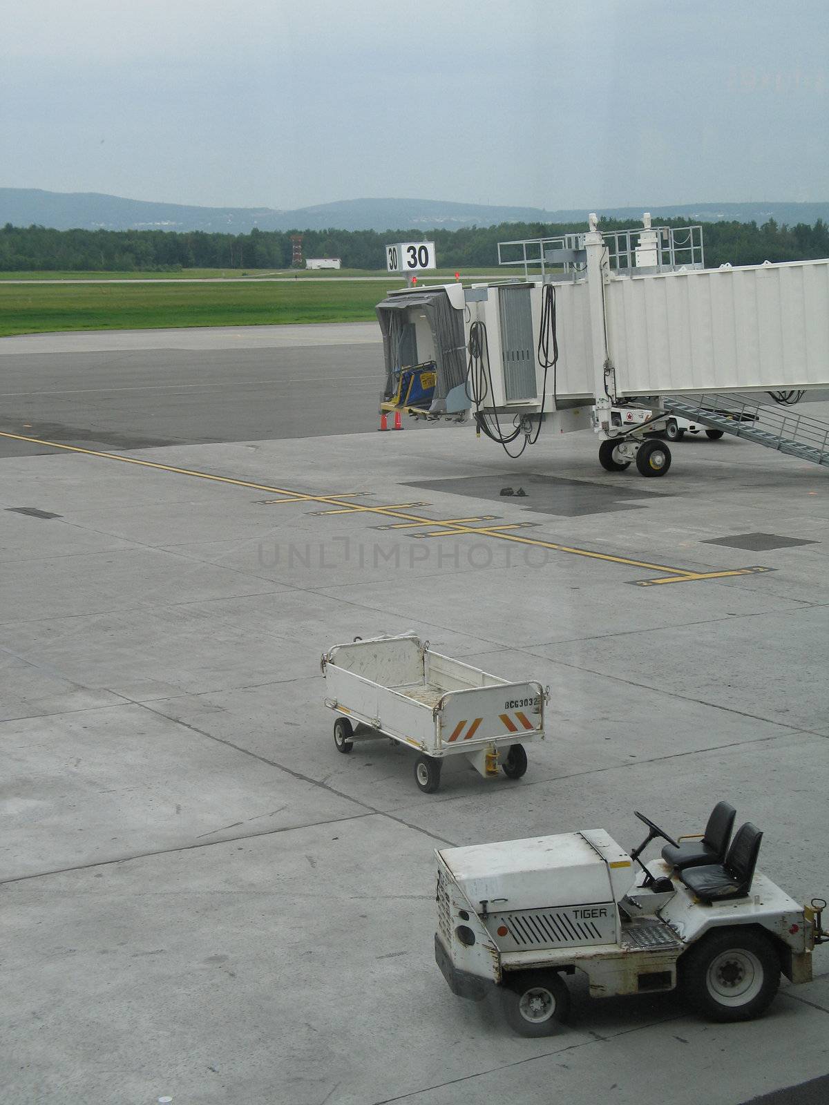 empty airplane gate with small trucks