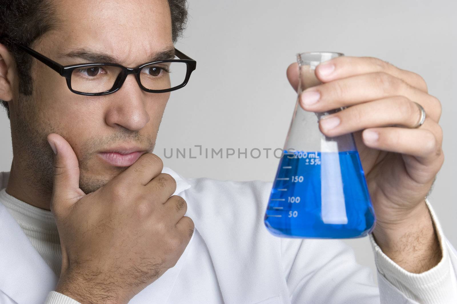 Thinking scientist man holding blue vial