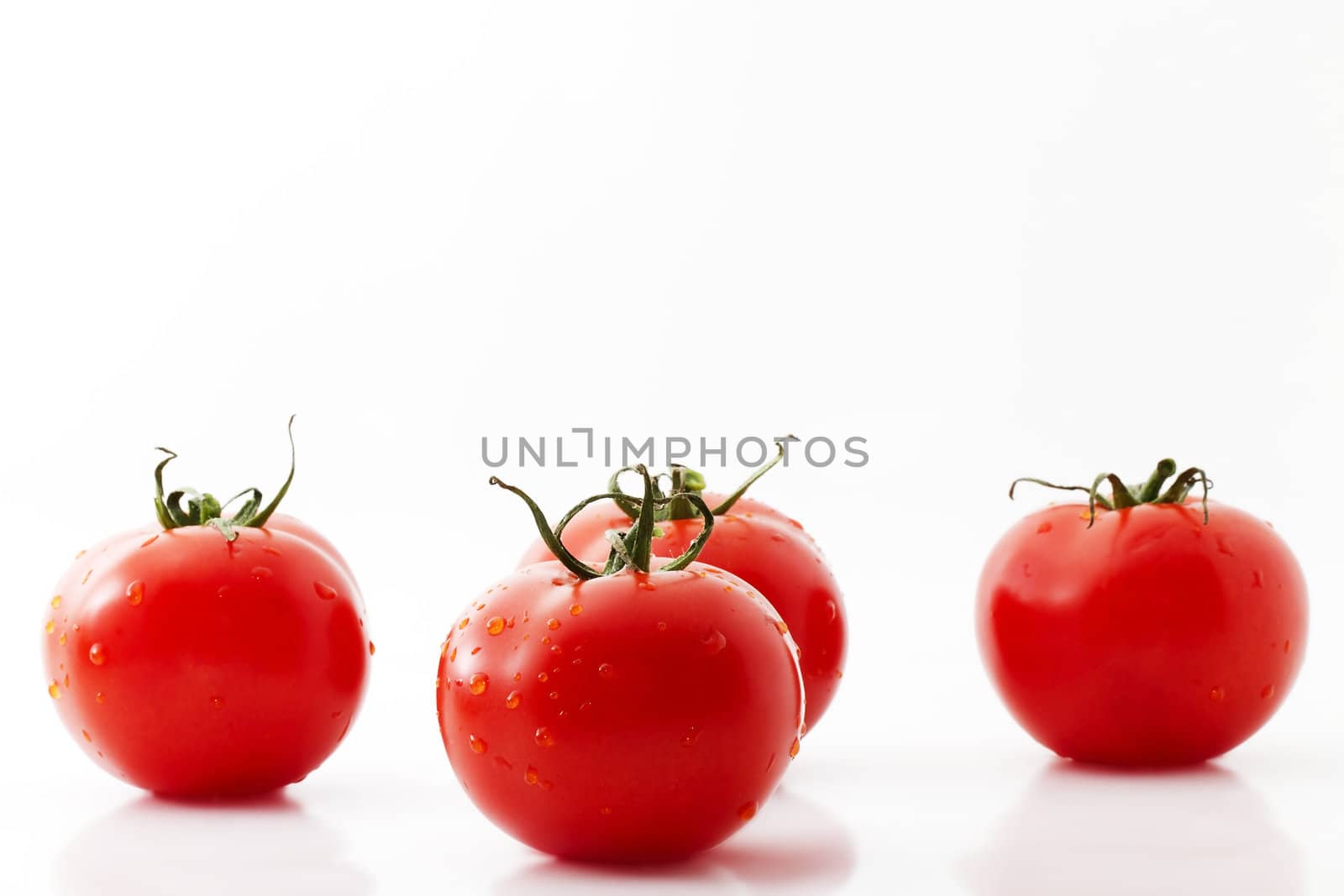 one tomato and three tomatoes on white background