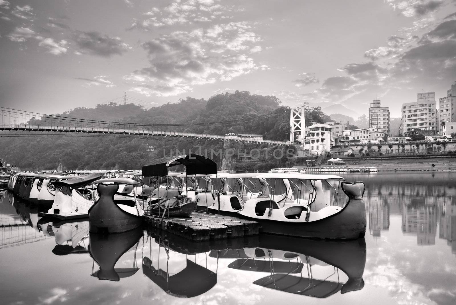 Landscape of river and boats near bridge and apartment.