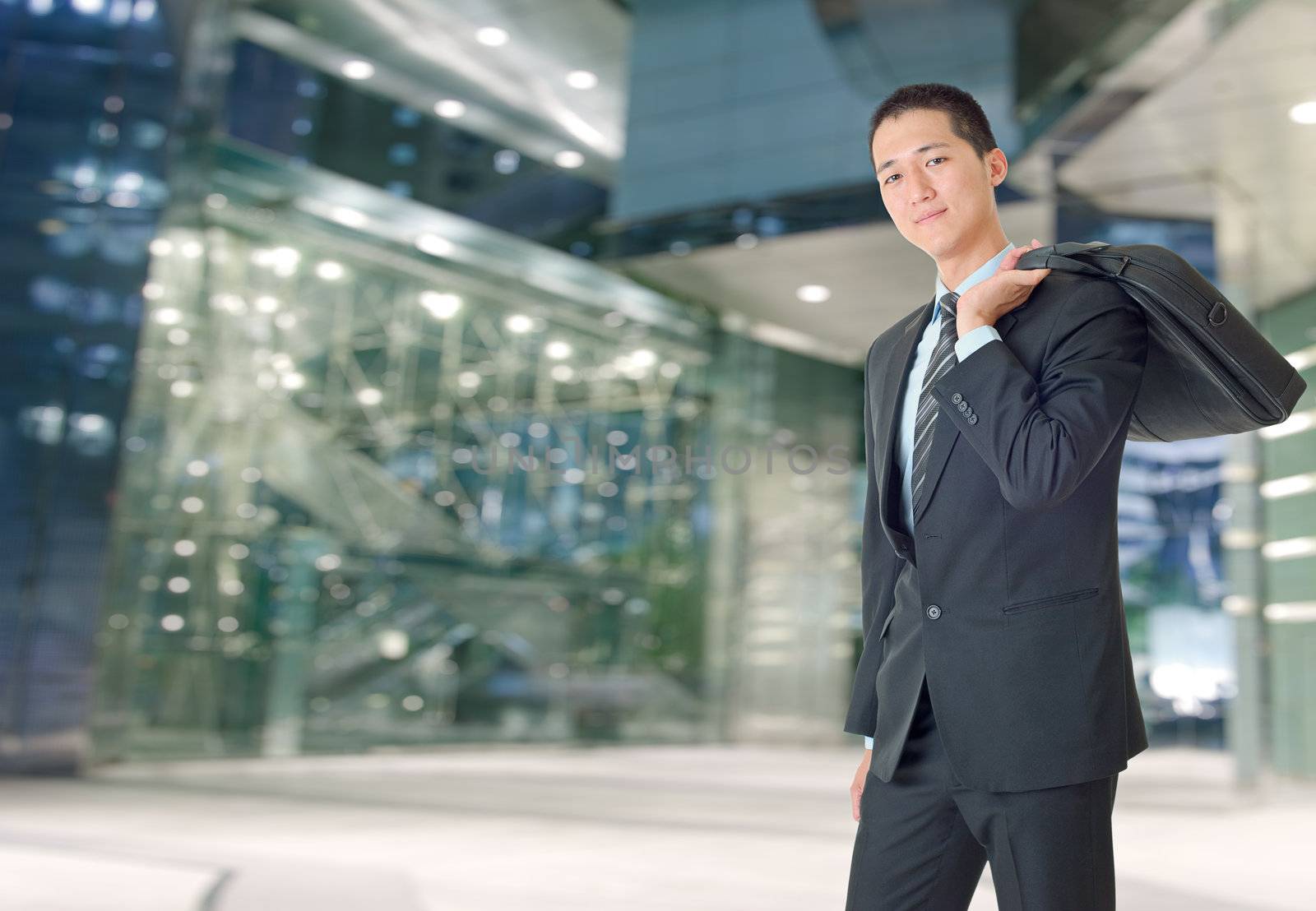 Happy young businessman of Asian outside of office.