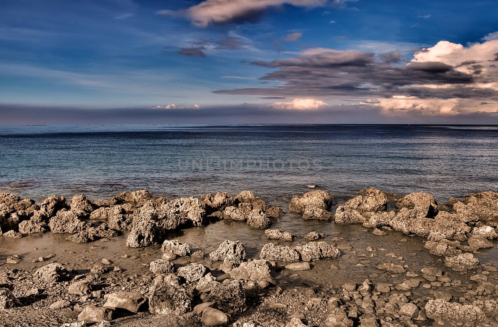 It is natural rocky coastline with beautiful blue sky.