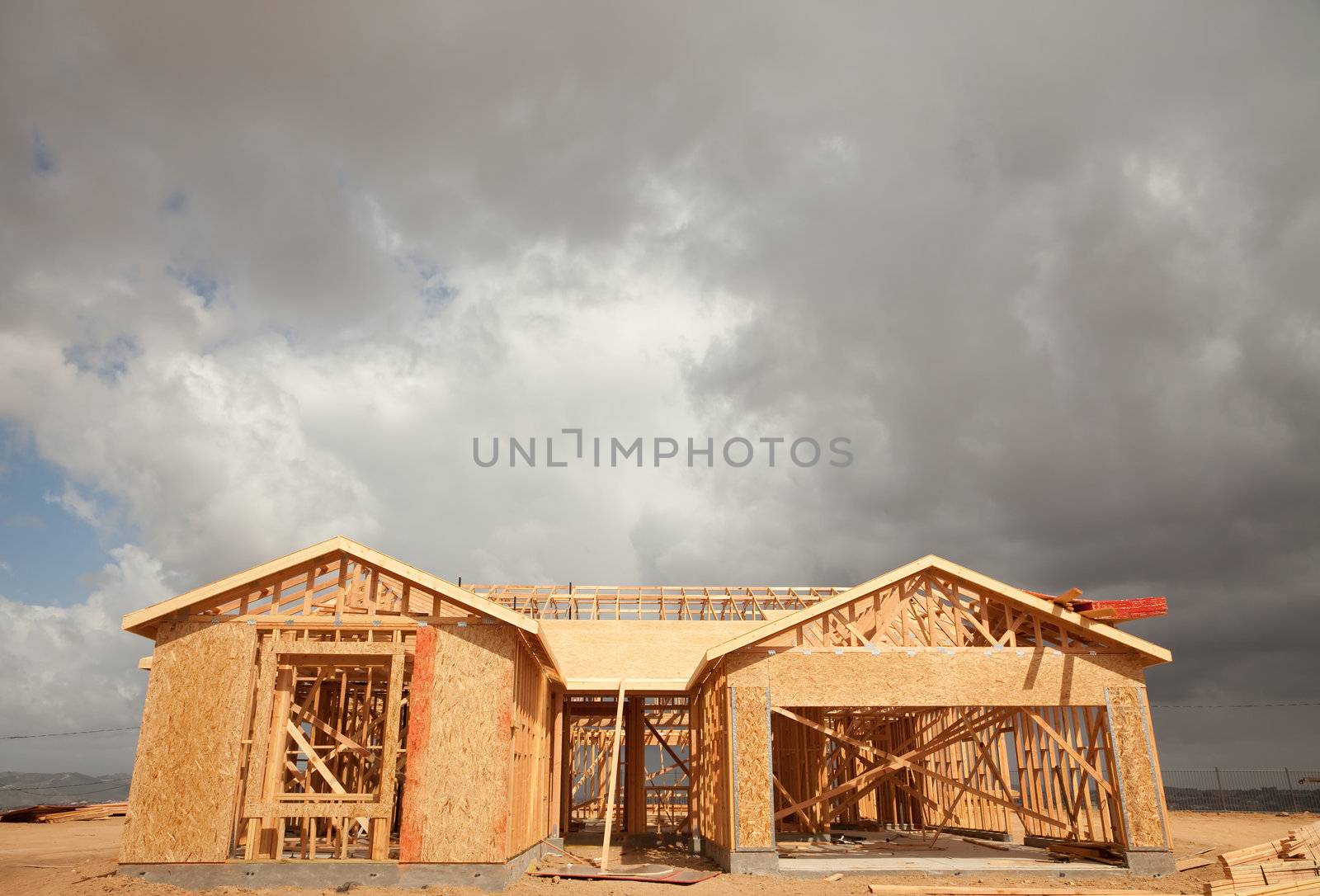 Abstract of New Home Construction Site Framing and Dramatic Clouds Overhead.