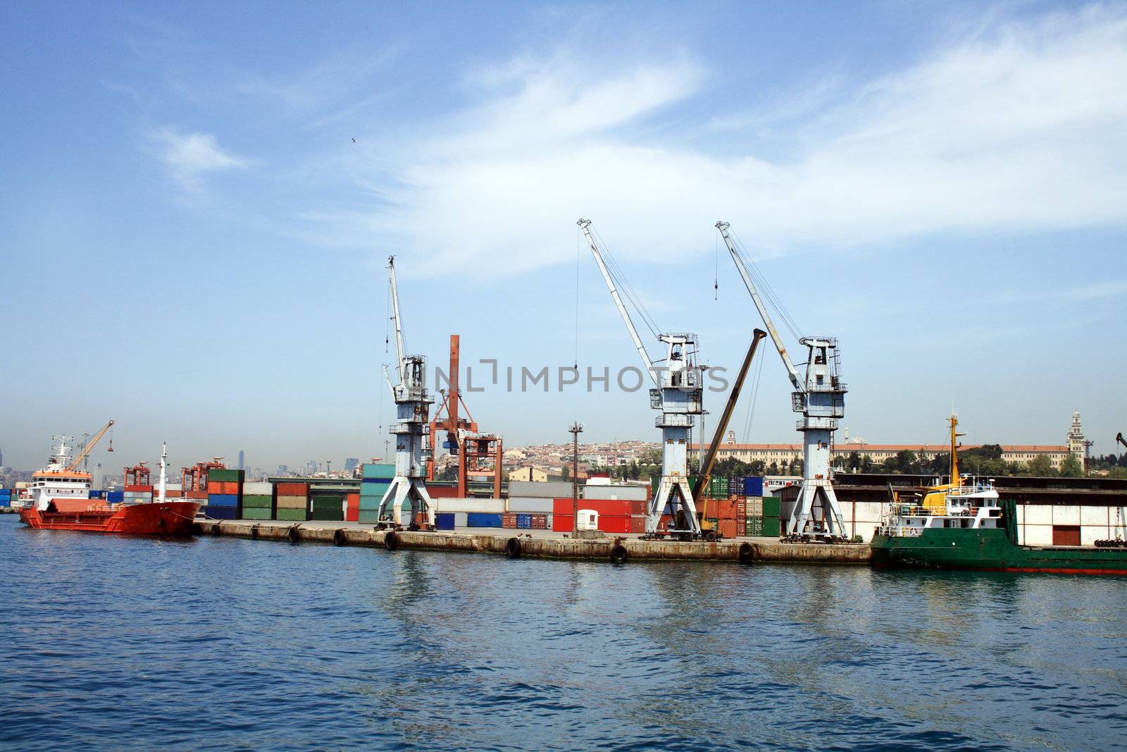 Sea panorama of container harbour with red vessel and cranes