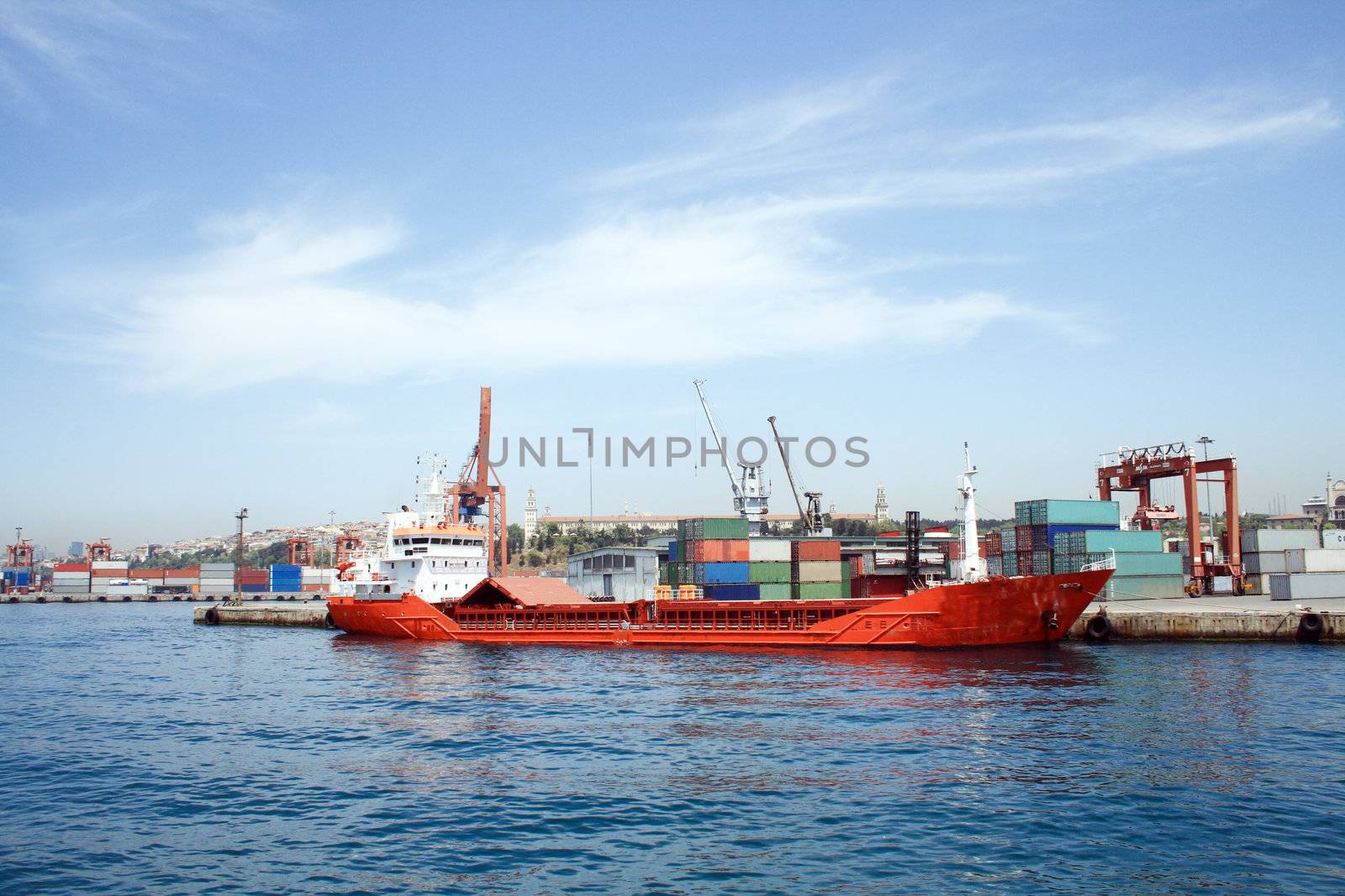 Sea panorama of container harbour with red vessel and cranes