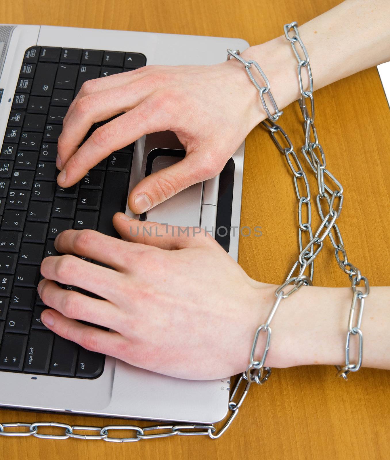 Hands wound around silvery chain on keyboard 