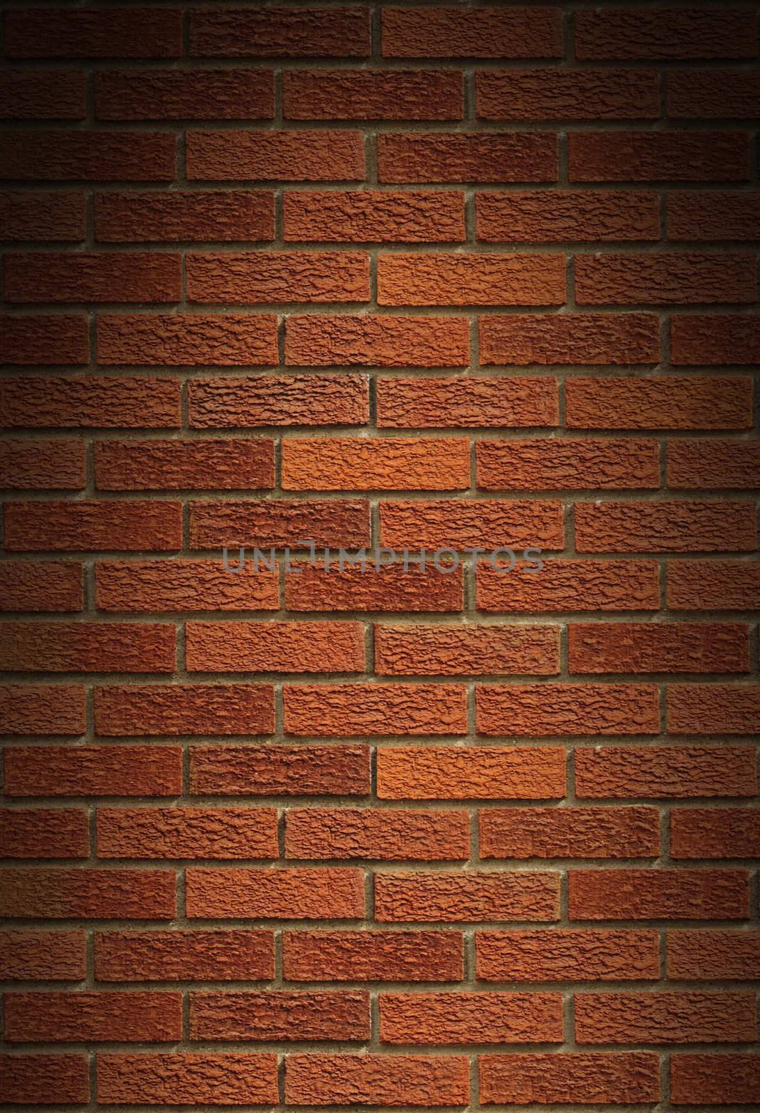 Red brick wall background lit dramatically from above