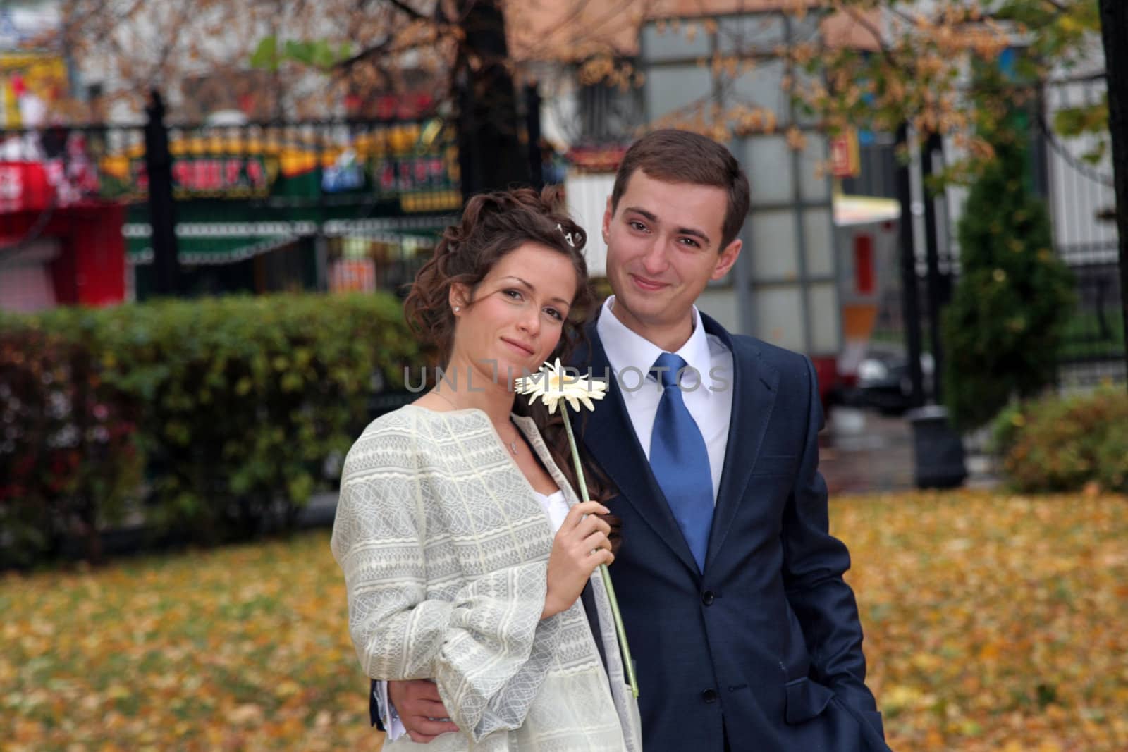 The groom and the bride walk in park in the autumn