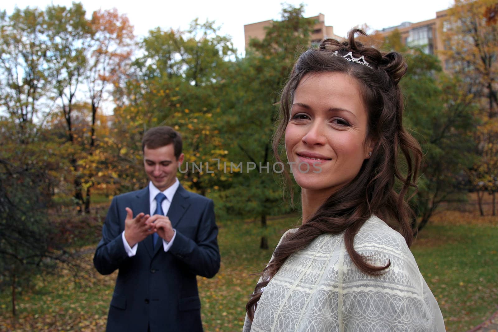 The groom and the bride walk in park in the autumn