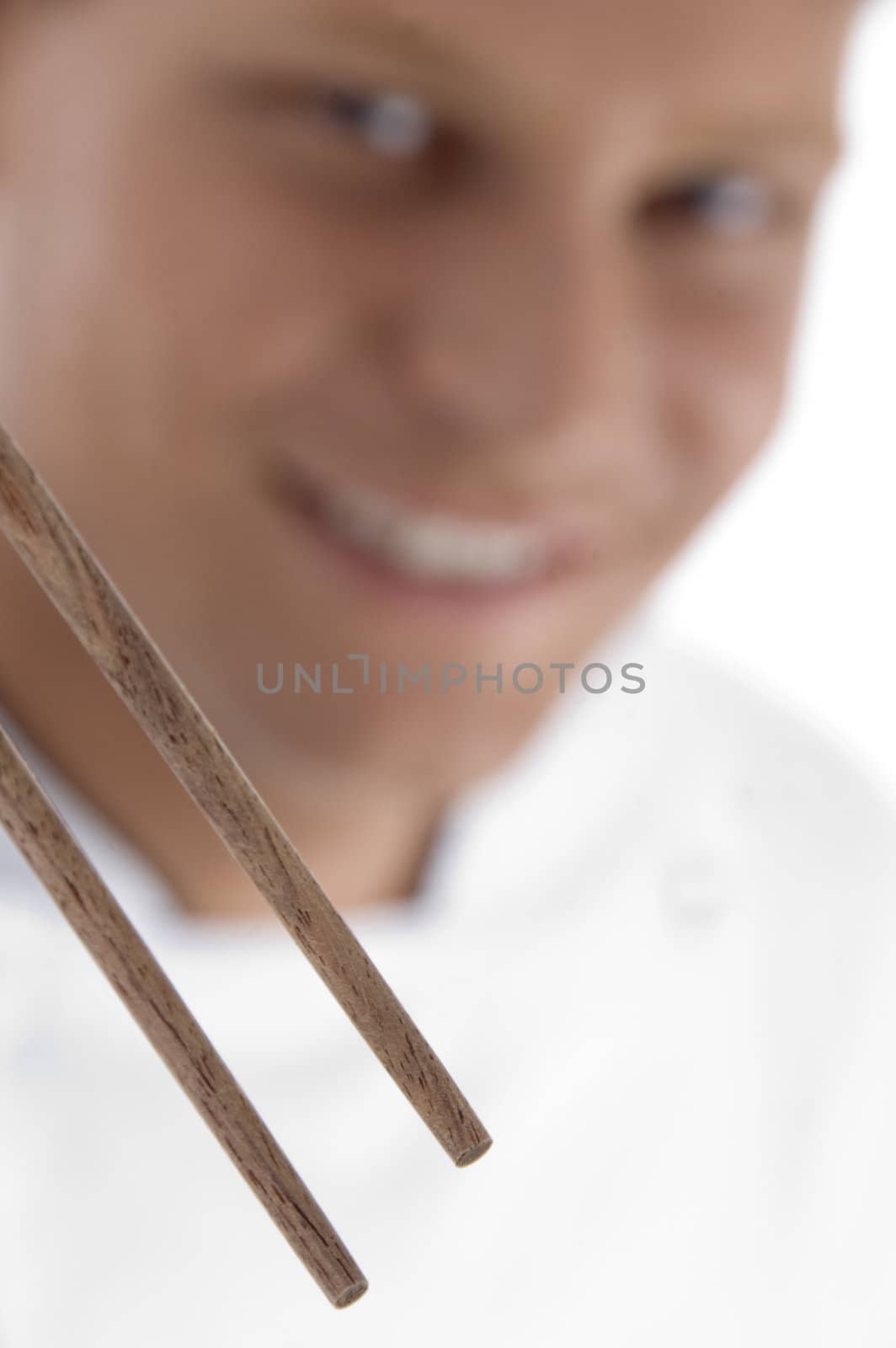 close up of chopsticks and chef in blur motion against white background