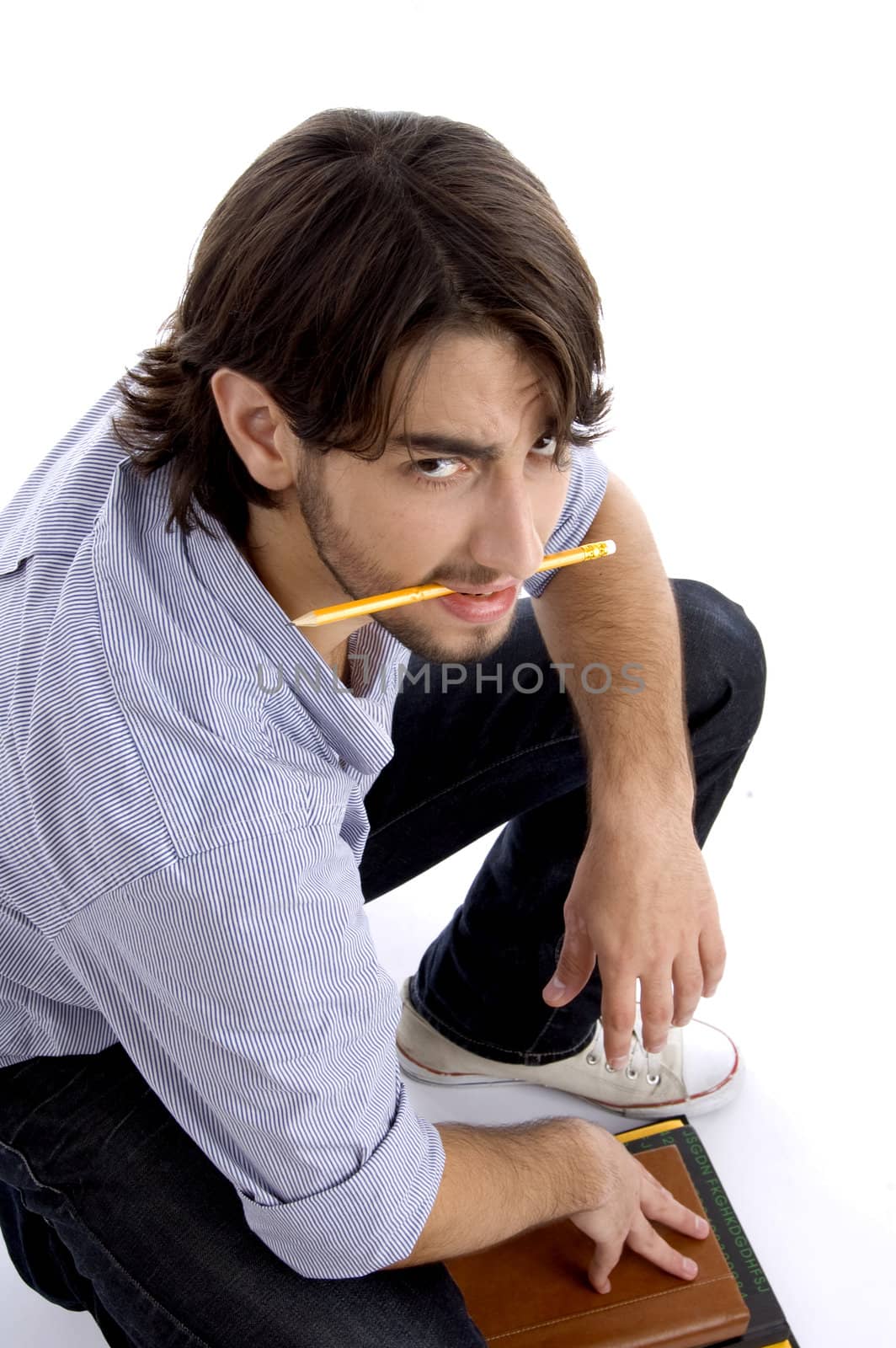 student holding pencil in mouth with white background