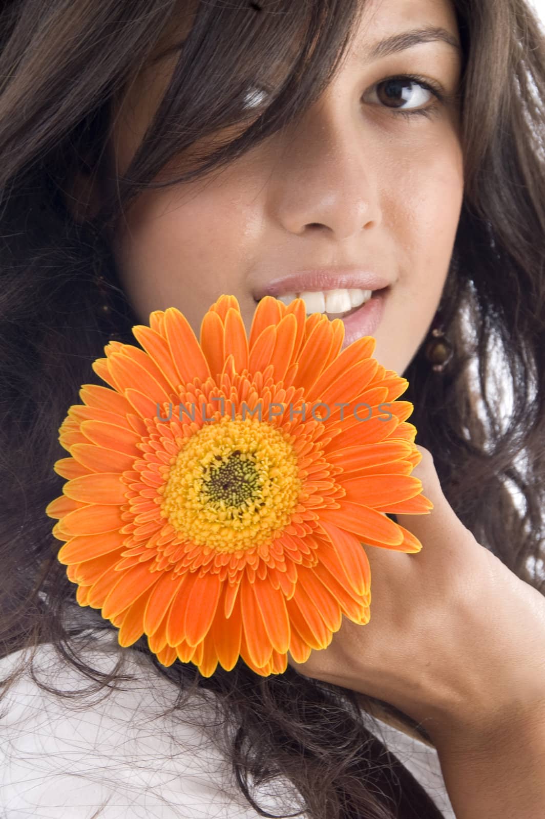 close up of beautiful model with orange gerbera against white background