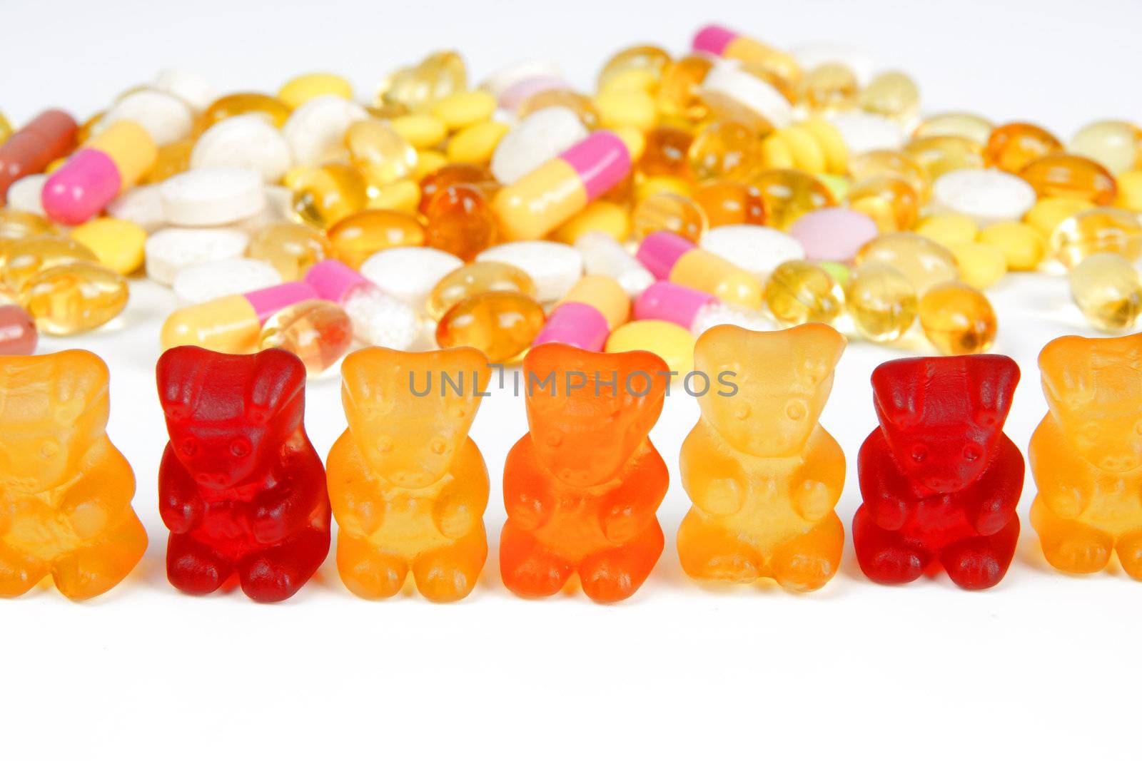 A stack of different coloorful tablets and gummy bears