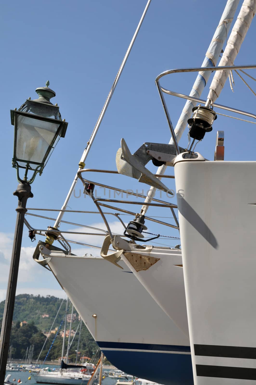 the prow of three sailboats in a dockyard