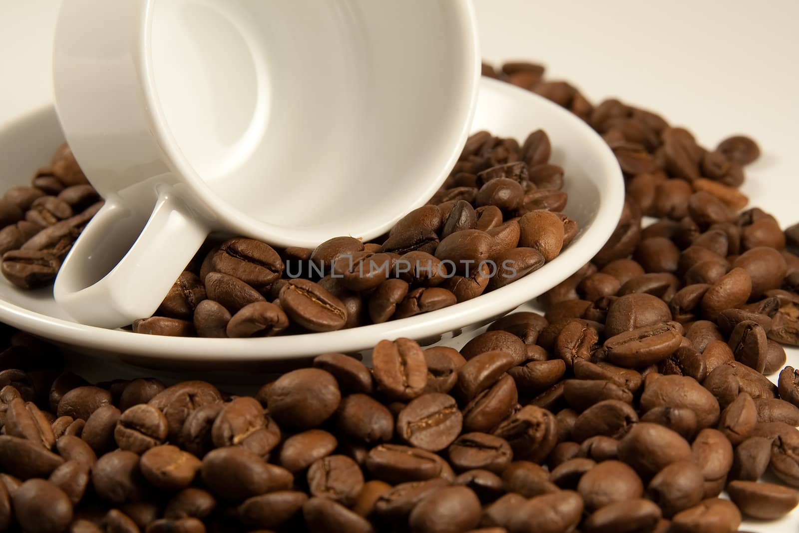 Closeup image of china cup on roasted coffee beans. Shallow DOF