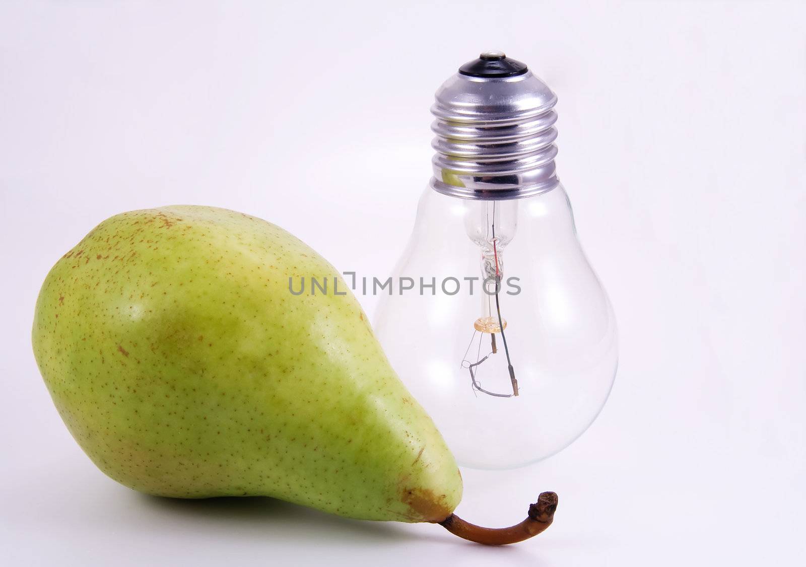Green pear and electric bulb on white background