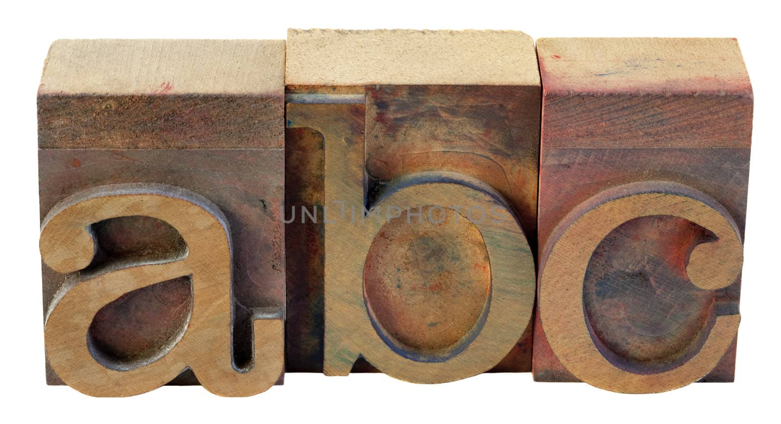 a, b, c - first letters of alphabet in vintage wooden letterpress type blocks, stained by color inks, isolated on white