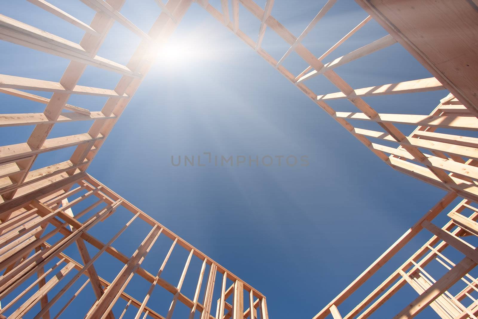 New Construction Framing Abstract with Sunburst Over Clear Blue Sky.