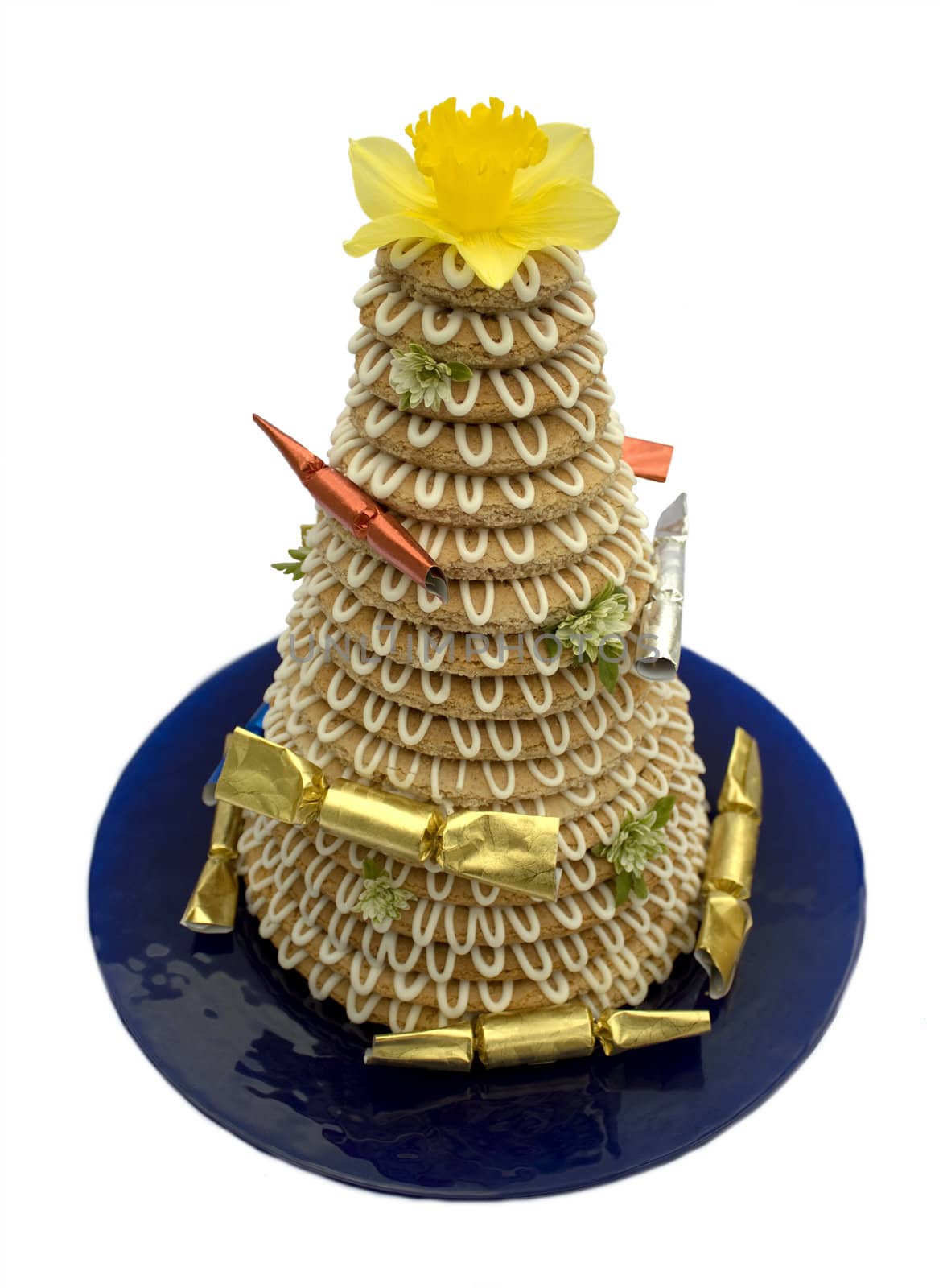 Traditional Scandinavian tower cake (kransekake) made from baked marzipan, decorated with flowers and crackers