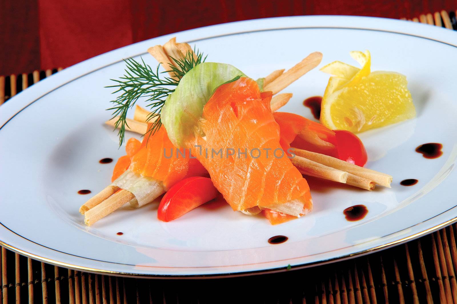 Salmon fish on a plate with salad, pepper, lemon, tomato.