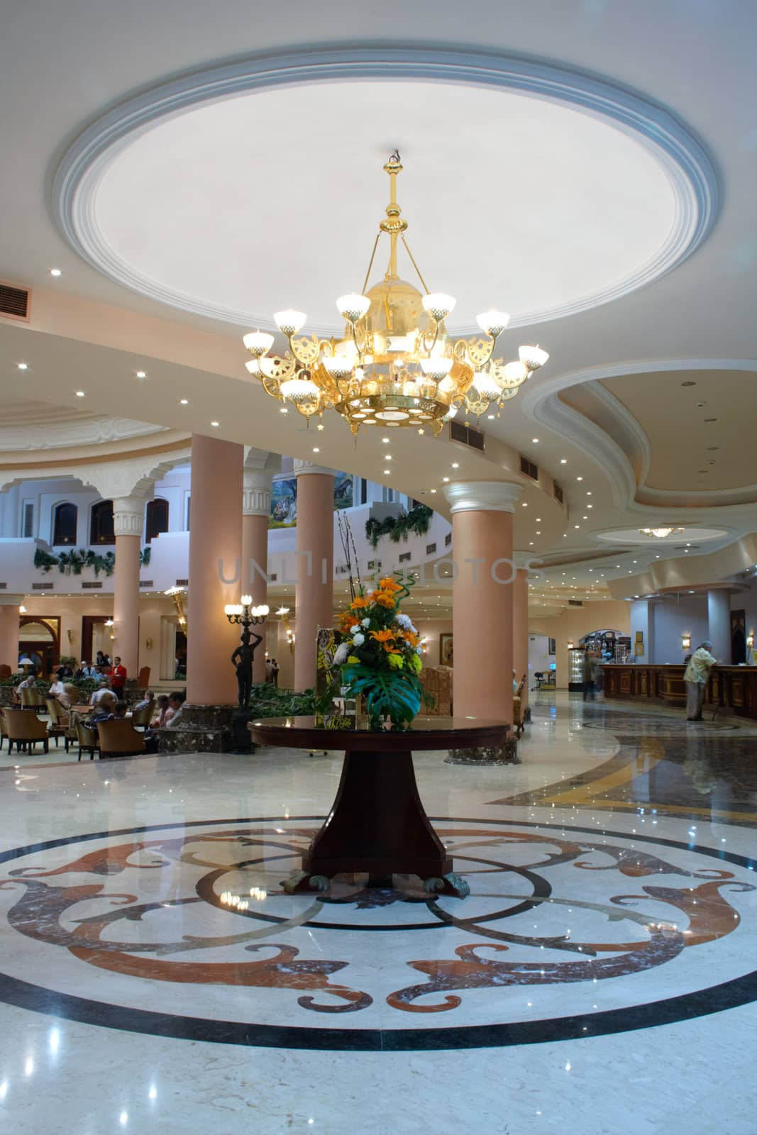 Hall in hotel with marble floor and flowers on the table