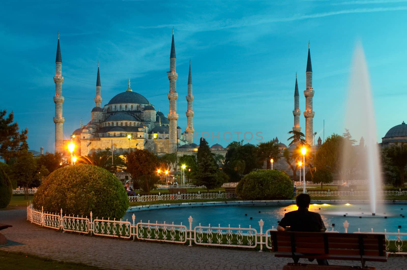 man sitting opposite blue mosque in istanbul in the evening