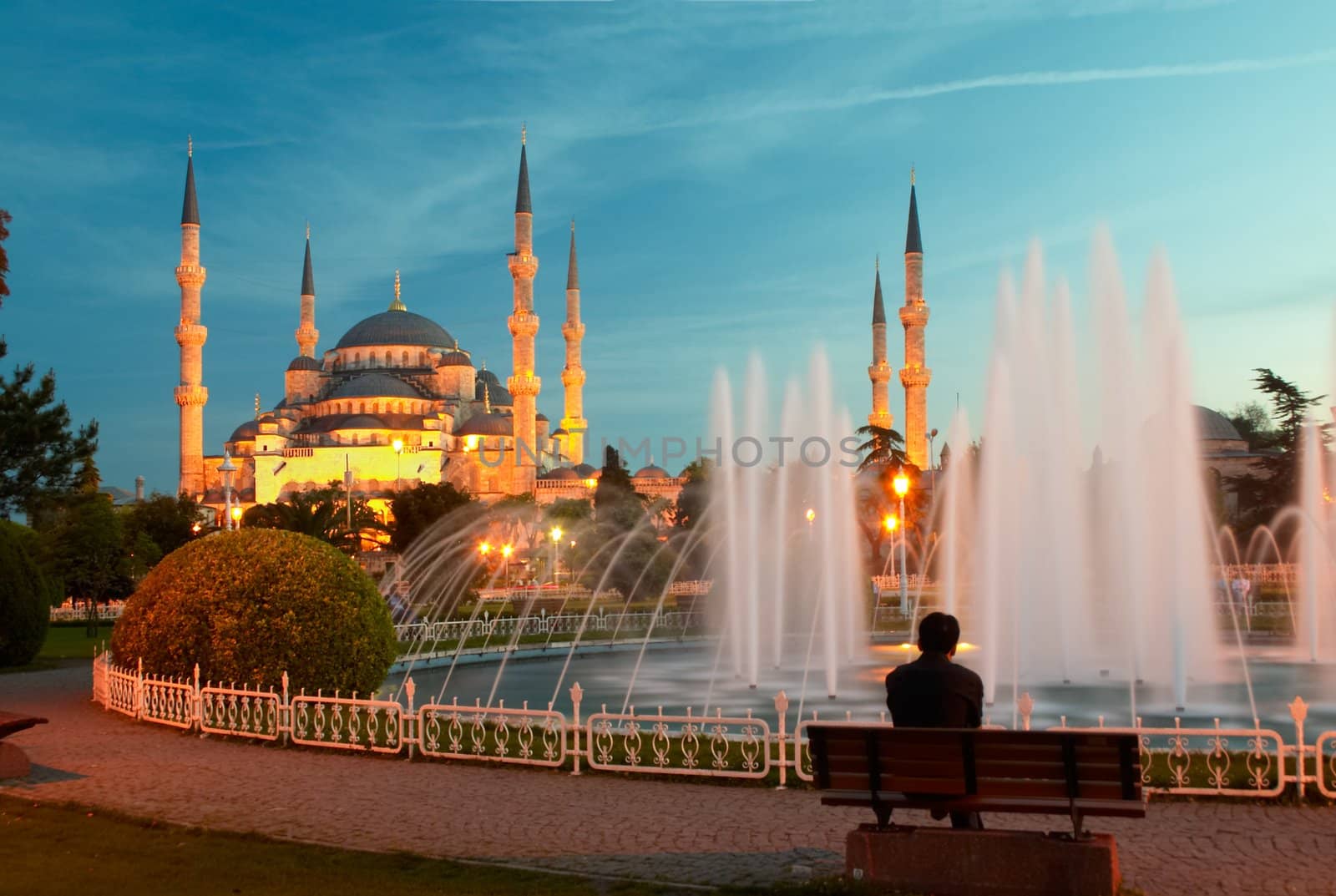 Man sitting on a bench opposite of blue mosque in Istanbul