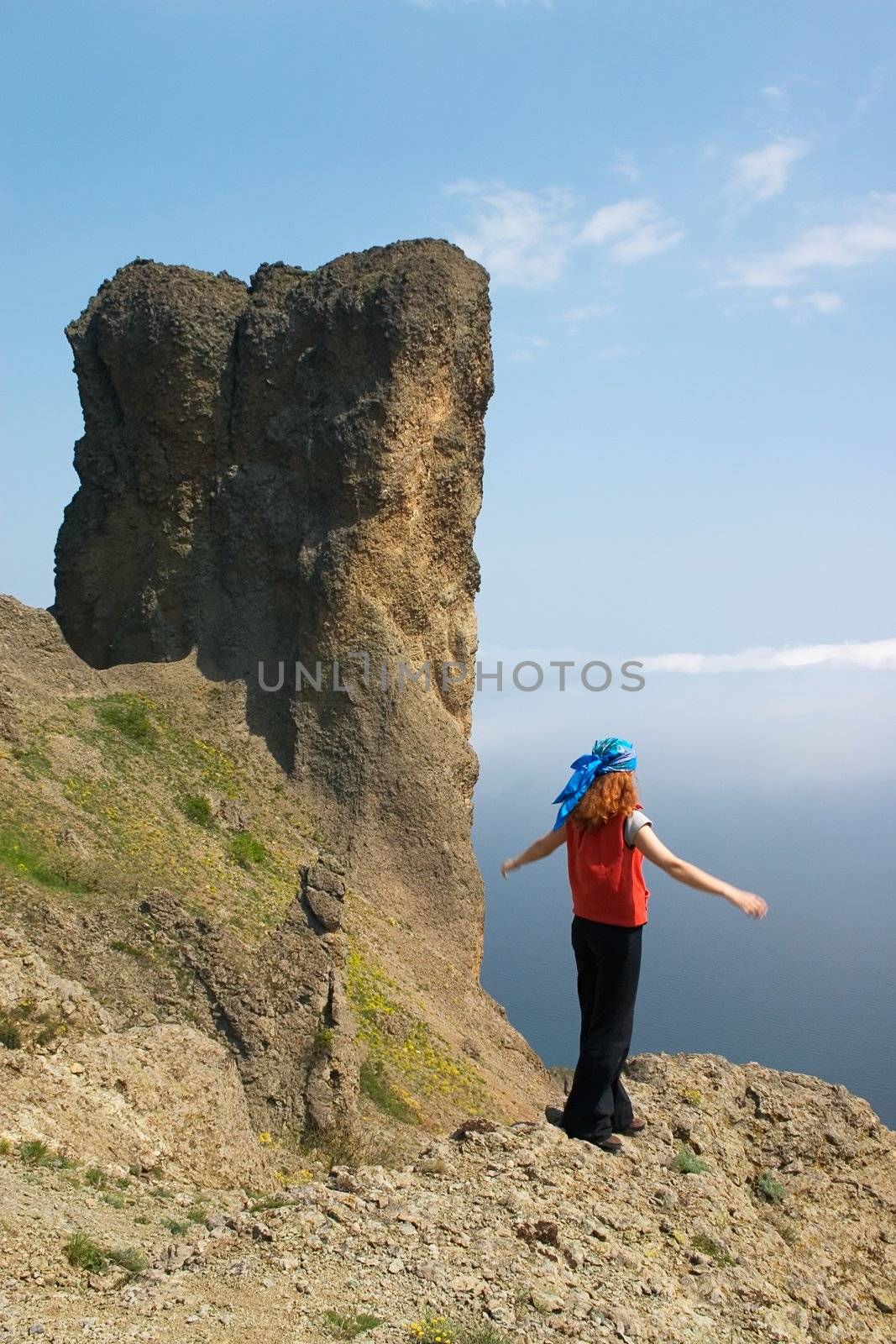 Girl standing on the steep in the mountains 
