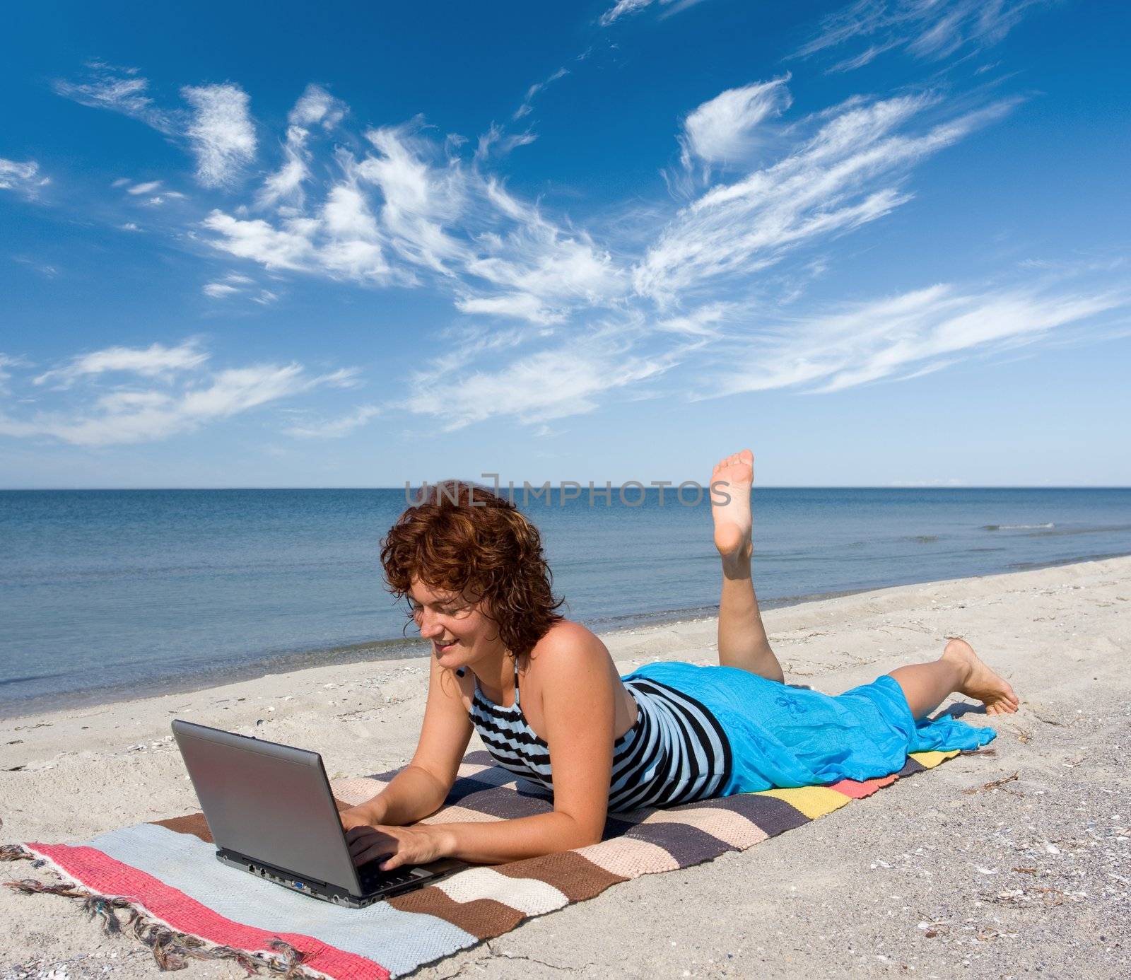woman with laptop on the sand sea beach
