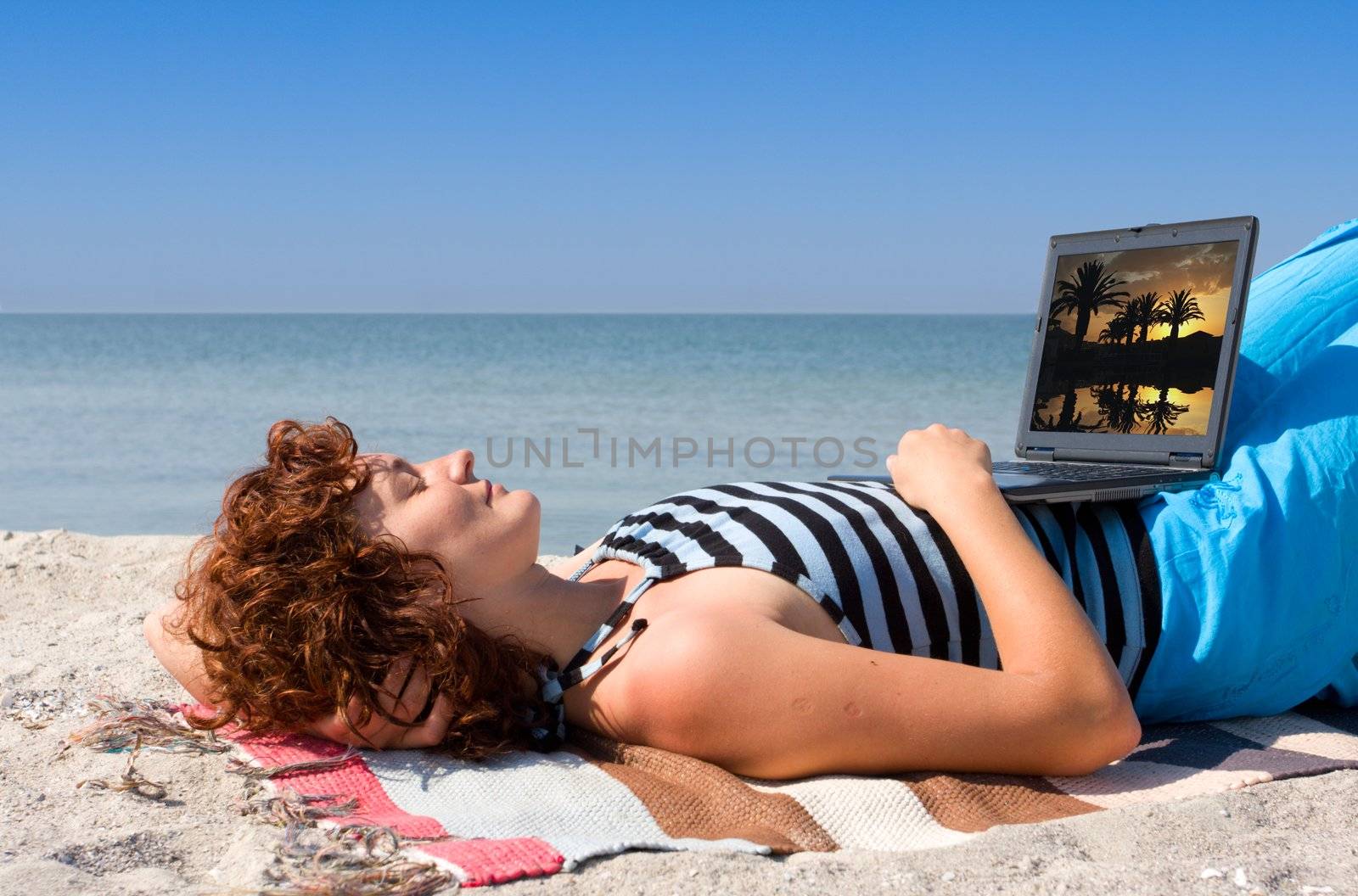 Girl sleep at sea beach with laptop computer