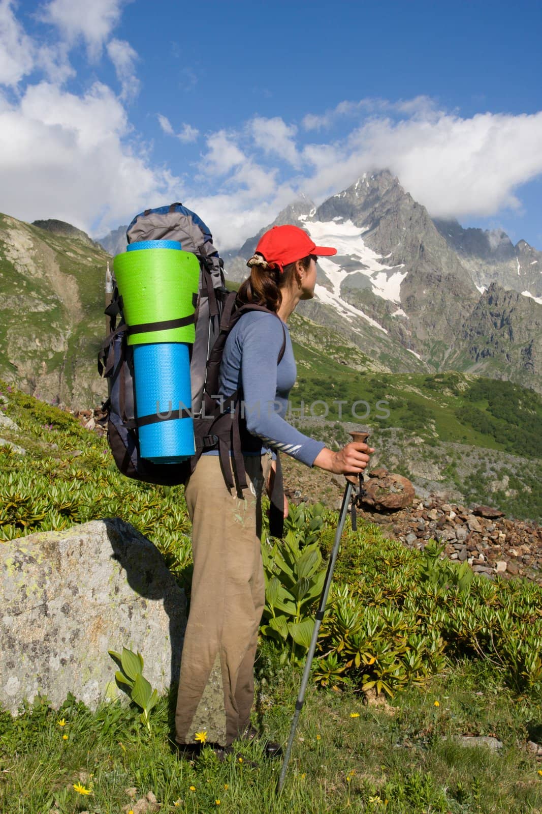 Backpacker girl looking to a high mountain