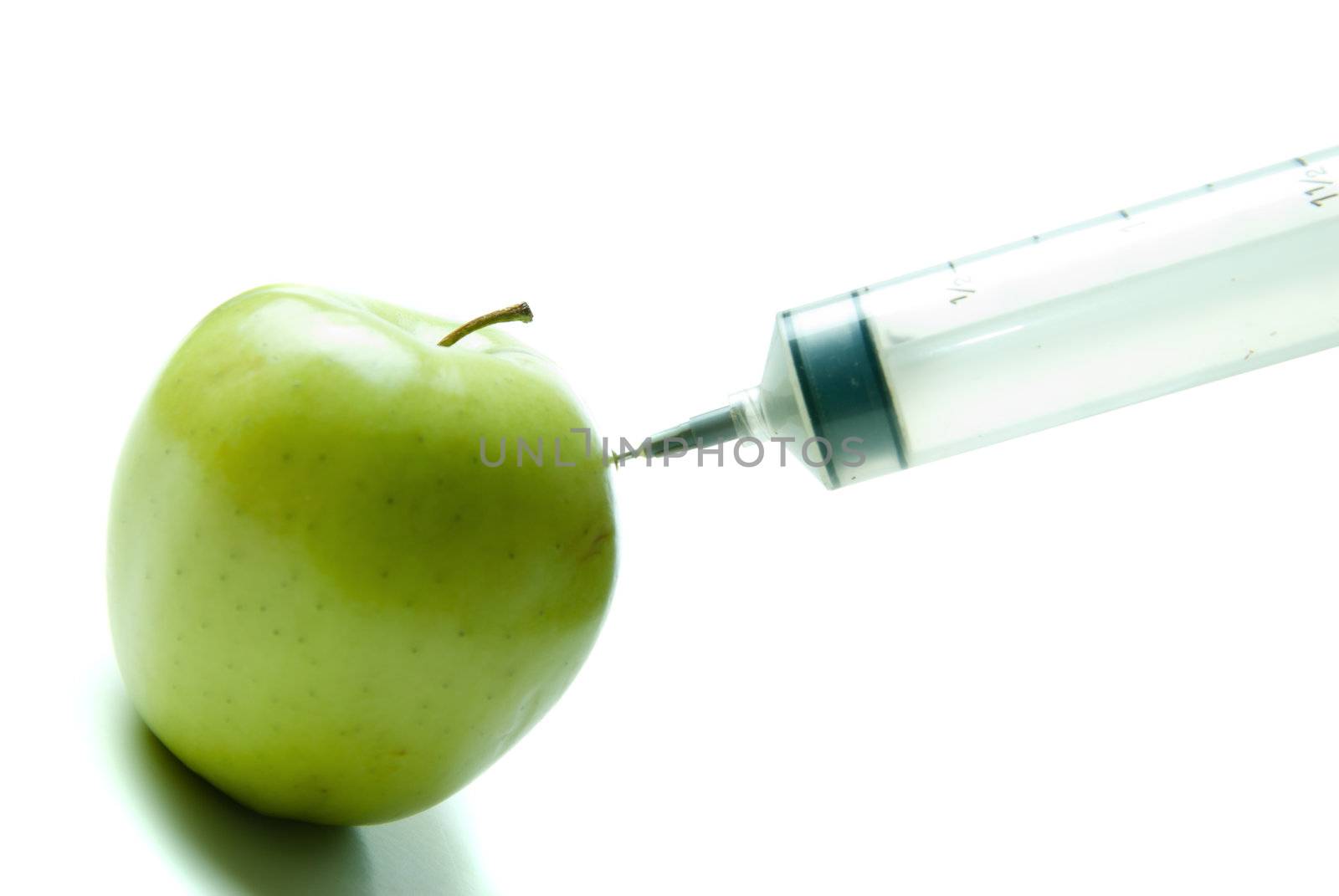 Concept image of a syringe injecting additional vitamins into food, shot on a white background.